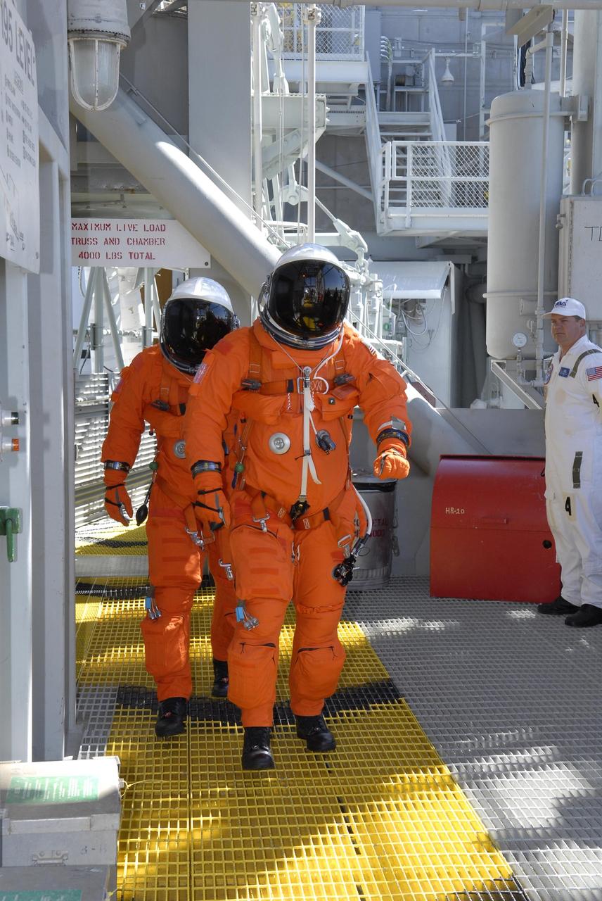 KENNEDY SPACE CENTER, FLA. --  On the 195-foot level of the fixed service structure on Launch Pad 39A,  STS-117 Mission Specialists James Reilly (front) and Danny Olivas head for the slidewire baskets. They and other crew members are practicing the emergency egress procedure to get off the pad, part of the prelaunch preparations known as terminal countdown demonstration test (TCDT). The TCDT also includes M-113 armored personnel carrier training and payload familiarization. The STS-117 mission is No. 21 to the International Space Station. Mission payloads aboard Atlantis include the S3/S4 integrated truss structure, a third set of solar arrays and batteries. The crew of six astronauts will install the truss to continue assembly of the station. Launch is scheduled for no earlier than March 15.   Photo credit: NASA/Kim Shiflett.