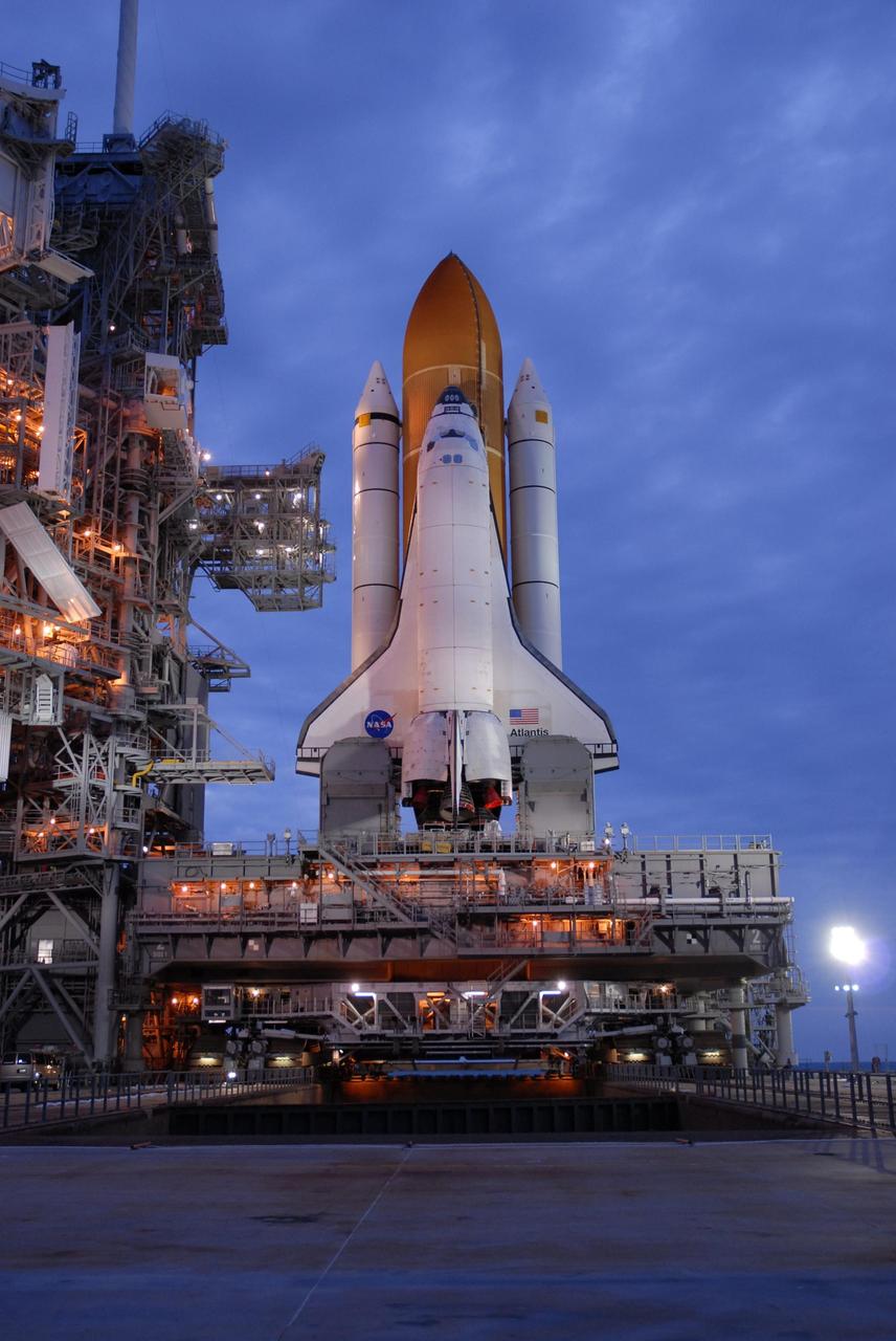 KENNEDY SPACE CENTER, FLA. --   Just before dawn on Launch Pad 39A, Space Shuttle Atlantis is revealed after rollback of the rotating service structure.  The shuttle is being rolled back to the Vehicle Assembly Building where it will be examined for hail damage.  A severe thunderstorm with golf ball-sized hail caused divots in the giant tank's foam insulation and minor surface damage to about 26 heat shield tiles on the shuttle's left wing. Further evaluation of the tank is necessary to get an accurate accounting of foam damage and determine the type of repair required and the time needed for that work.  A new target launch date has not been determined, but teams will focus on preparing Atlantis for liftoff in late April.  Photo credit: NASA/Amanda Diller