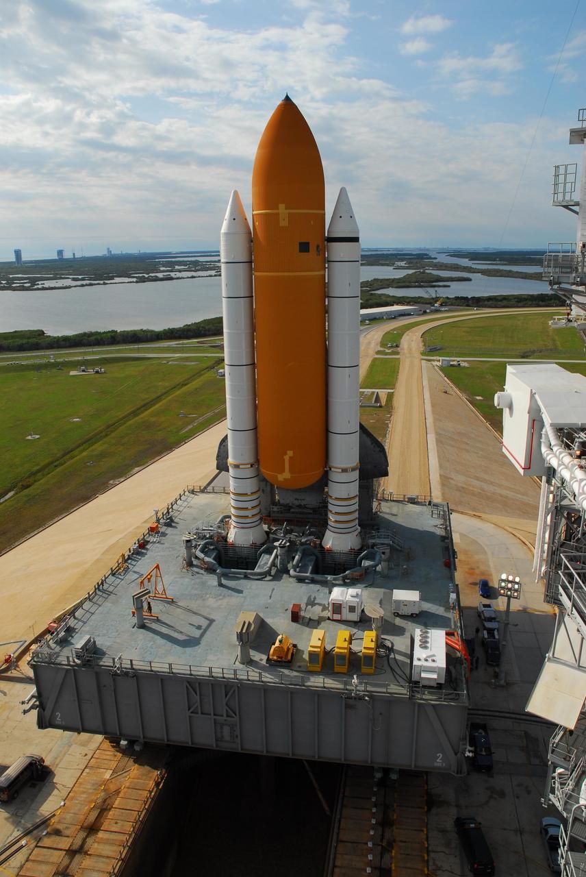 KENNEDY SPACE CENTER, FLA. --   Seen from behind the mobile launcher platform, the orange external tank and solid rocket boosters all but hide Atlantis.  The crawlerway stretches in a curve on the other side.  The shuttle is being rolled back to the Vehicle Assembly Building where it will be examined for hail damage.  A severe thunderstorm with golf ball-sized hail caused divots in the giant tank's foam insulation and minor surface damage to about 26 heat shield tiles on the shuttle's left wing. Further evaluation of the tank is necessary to get an accurate accounting of foam damage and determine the type of repair required and the time needed for that work.  A new target launch date has not been determined, but teams will focus on preparing Atlantis for liftoff in late April.  Photo credit: NASA/Amanda Diller