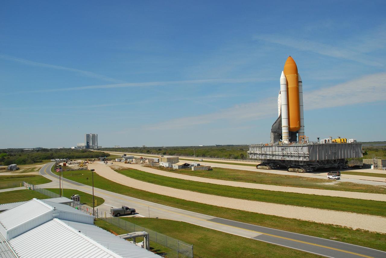KENNEDY SPACE CENTER, FLA. --  Under blue sky streaked with contrails, Space Shuttle Atlantis, atop the mobile launcher platform, is being rolled back to the Vehicle Assembly Building (at left in the background) from Launch Pad 39A.  In the VAB, the shuttle will be examined for hail damage.  A severe thunderstorm with golf ball-sized hail caused divots in the giant tank's foam insulation and minor surface damage to about 26 heat shield tiles on the shuttle's left wing. Further evaluation of the tank is necessary to get an accurate accounting of foam damage and determine the type of repair required and the time needed for that work.  A new target launch date has not been determined, but teams will focus on preparing Atlantis for liftoff in late April.  Photo credit: NASA/Amanda Diller