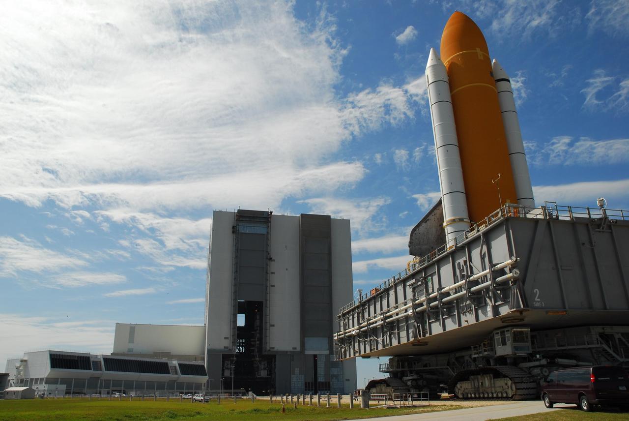 KENNEDY SPACE CENTER, FLA. --  Space Shuttle Atlantis, atop the mobile launcher platform, rolls toward the Vehicle Assembly Building.  In the VAB, the shuttle will be examined for hail damage. A severe thunderstorm with golf ball-sized hail caused divots in the giant tank's foam insulation and minor surface damage to about 26 heat shield tiles on the shuttle's left wing. Further evaluation of the tank is necessary to get an accurate accounting of foam damage and determine the type of repair required and the time needed for that work.  A new target launch date has not been determined, but teams will focus on preparing Atlantis for liftoff in late April.  Photo credit: NASA/Amanda Diller