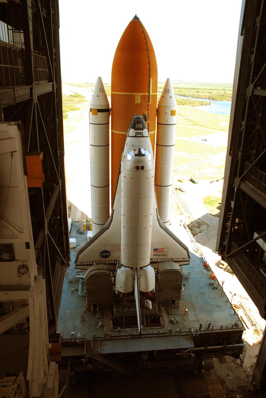 KENNEDY SPACE CENTER, FLA. --  Viewed from inside the Vehicle Assembly Building, Space Shuttle Atlantis, atop the mobile launcher platform, rolls into high bay 1 after leaving Launch Pad 39A.  A severe thunderstorm with golf ball-sized hail caused divots in the giant tank's foam insulation and minor surface damage to about 26 heat shield tiles on the shuttle's left wing. Further evaluation of the tank is necessary to get an accurate accounting of foam damage and determine the type of repair required and the time needed for that work.  A new target launch date has not been determined, but teams will focus on preparing Atlantis for liftoff in late April.  Photo credit: NASA/Amanda Diller