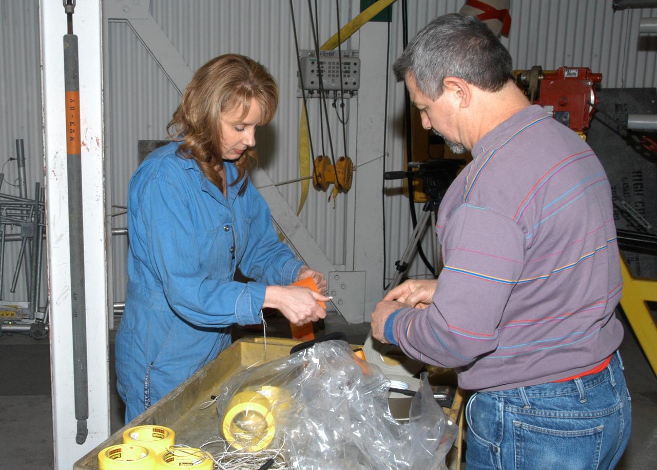 KENNEDY SPACE CENTER, FLA. -- Technicians in the Vehicle Assembly Building prepare materials that will be used during repair of the nose cone on Atlantis' external tank.  A severe thunderstorm with golf ball-sized hail caused visible divots in the giant tank's foam insulation and minor surface damage to about 26 heat shield tiles on the shuttle's left wing. Further evaluation of the tank is necessary to get an accurate accounting of foam damage and determine the type of repair required and the time needed for that work. A new target launch date has not been determined, but teams will focus on preparing Atlantis for liftoff in late April on mission STS-117. Photo credit: NASA/George Shelton