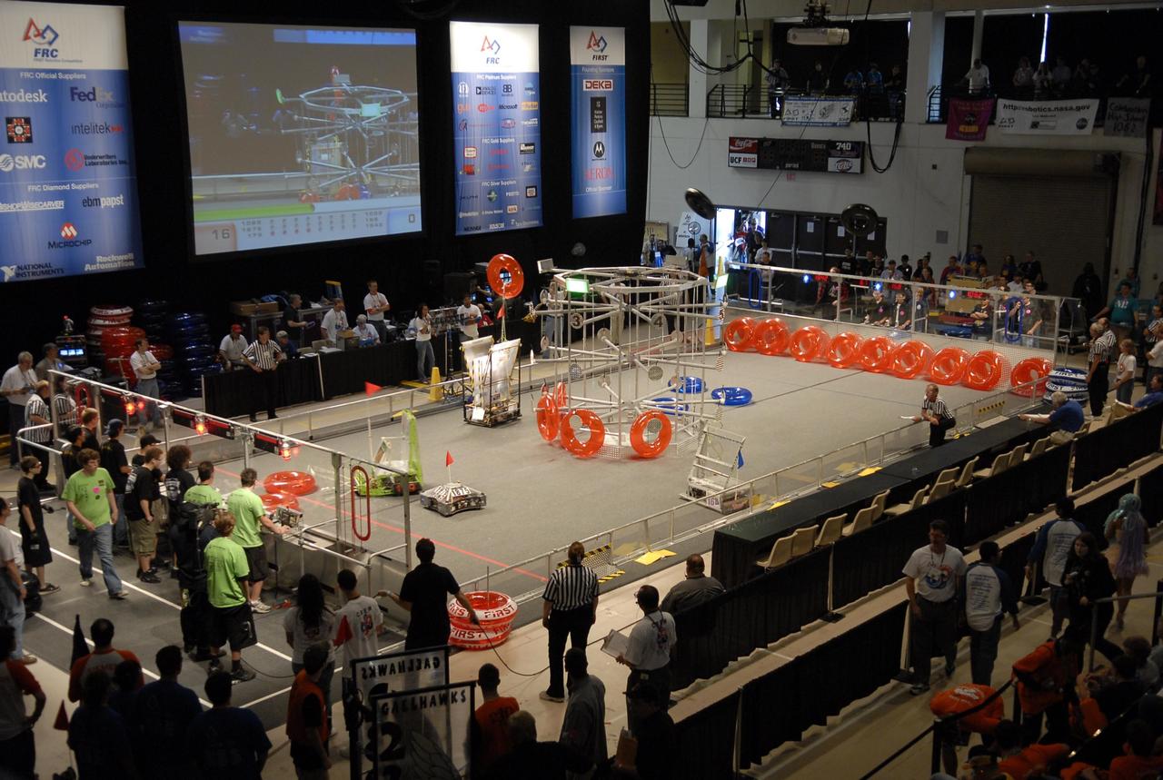 KENNEDY SPACE CENTER, FLA. --   Competing robots try to loop the large metal target with colored rings.  The robots are products of student teams taking part in the FIRST robotics event held at the University of Central Florida Arena March 8-10. The FIRST, or For Inspiration and Recognition of Science and Technology, Robotics Competition challenges teams of young people and their mentors to solve a common problem in a six-week timeframe using a standard "kit of parts" and a common set of rules. Teams build robots from the parts and enter them in a series of competitions designed by FIRST founder Dean Kamen and Dr. Woodie Flowers, chairman and vice chairman of the Executive Advisory Board respectively, and a committee of engineers and other professionals. FIRST redefines winning for these students. Teams are rewarded for excellence in design, demonstrated team spirit, gracious professionalism and maturity, and ability to overcome obstacles. Scoring the most points is a secondary goal. Winning means building partnerships that last. Photo credit: NASA/Kim Shiflett