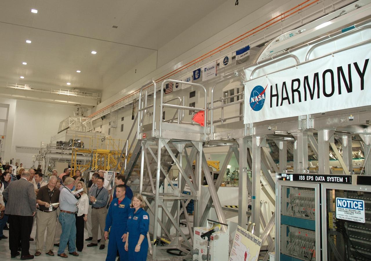 KENNEDY SPACE CENTER, FLA. --  In the Space Station Processing Facility, Mission STS-120 Pilot George Zamka (left) and Commander Pam Melroy stand in front of the Node 2 module with it's new name, Harmony, unveiled. The name, Harmony, was chosen from an academic competition involving thousands of students in kindergarten through high school. The Node 2 Challenge required students to learn about the International Space Station, build a scale model of the module, and write an essay explaining their proposed name. This will be the first U.S. piece of the space station named by someone other than a NASA official.  Node 2 is a pressurized module that will act as a connecting port and passageway to additional international science labs and supply spacecraft. It also will be a work platform for the station's robotic arm. The module is scheduled to fly on mission STS-120 aboard Space Shuttle Atlantis targeted for later this year.   Photo credit: NASA/Jim Grossmann