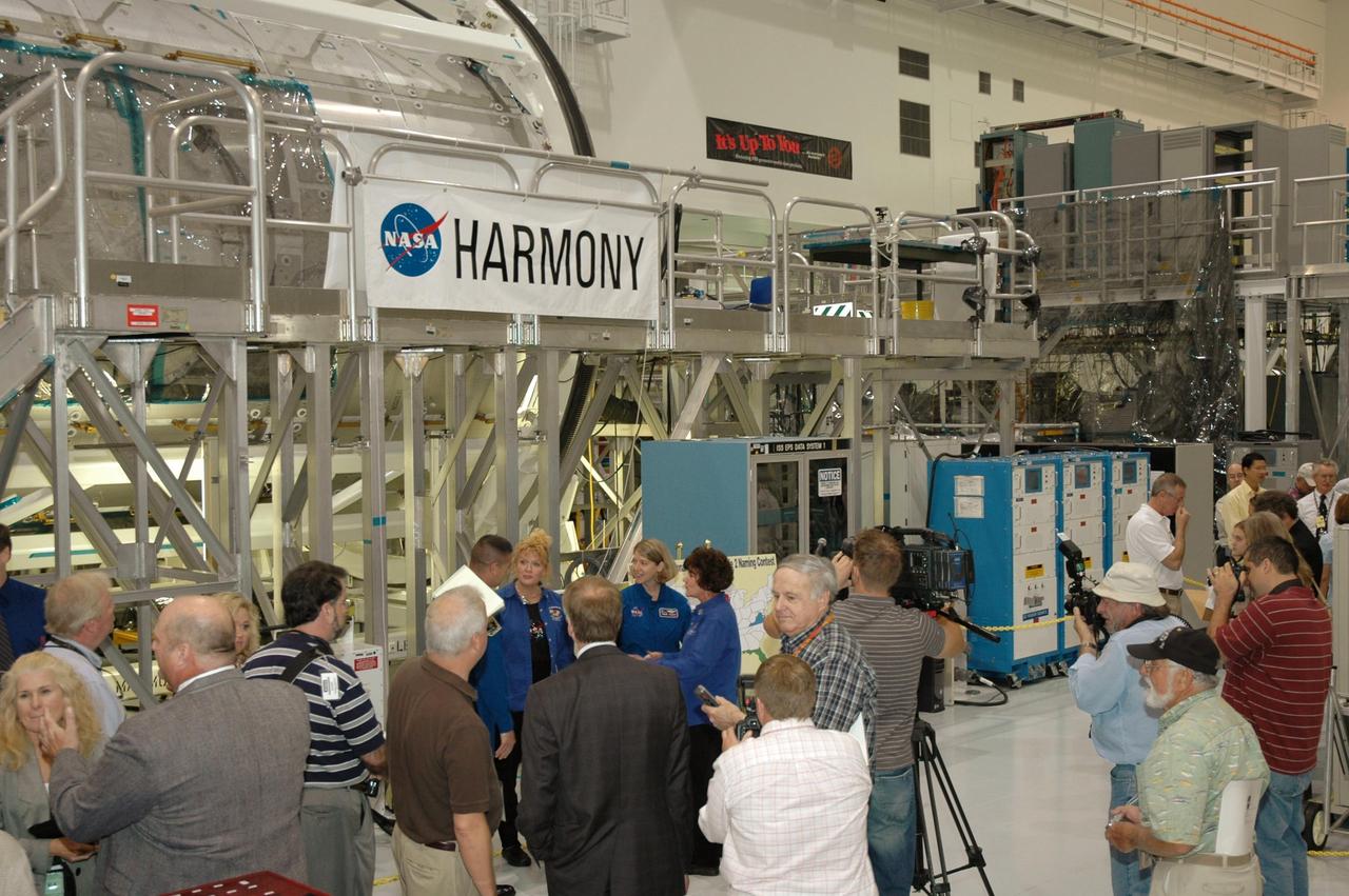 KENNEDY SPACE CENTER, FLA. --  In the Space Station Processing Facility, Mission STS-120 Pilot George Zamka (left, partially hidden) and Commander Pam Melroy (second from right in group), talk with members of the media and guests after a ceremony to unveil NASA's Node 2 module's new name, Harmony.  The name, Harmony, was chosen from an academic competition involving thousands of students in kindergarten through high school. The Node 2 Challenge required students to learn about the International Space Station, build a scale model of the module, and write an essay explaining their proposed name. This will be the first U.S. piece of the space station named by someone other than a NASA official.  Node 2 is a pressurized module that will act as a connecting port and passageway to additional international science labs and supply spacecraft. It also will be a work platform for the station's robotic arm. The module is scheduled to fly on mission STS-120 aboard Space Shuttle Atlantis targeted for later this year.   Photo credit: NASA/Jim Grossmann