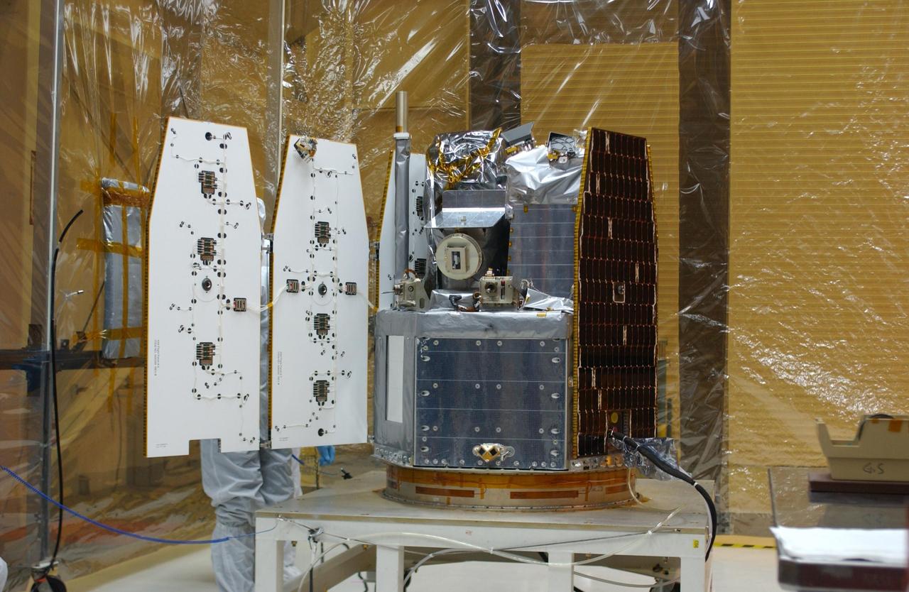 VANDENBERG AIR FORCE BASE, CALIF.  --  Inside the clean-room "tent" of Building 1555 at North Vandenberg Air Force Base, two of the solar array panels on the AIM spacecraft are deployed for testing. Inside are the instruments that will study polar mesospheric clouds located at the edge of space. The AIM spacecraft will fly three instruments designed to study those clouds located at the edge of space, 50 miles above the Earth's surface in the coldest part of the planet's atmosphere. The mission's primary goal is to explain why these clouds form and what has caused them to become brighter and more numerous and appear at lower latitudes in recent years. AIM's results will provide the basis for the study of long-term variability in the mesospheric climate and its relationship to global climate change. AIM is scheduled to be mated to the Pegasus XL during the second week of April, after which final inspections will be conducted.  Launch is scheduled for April 25.