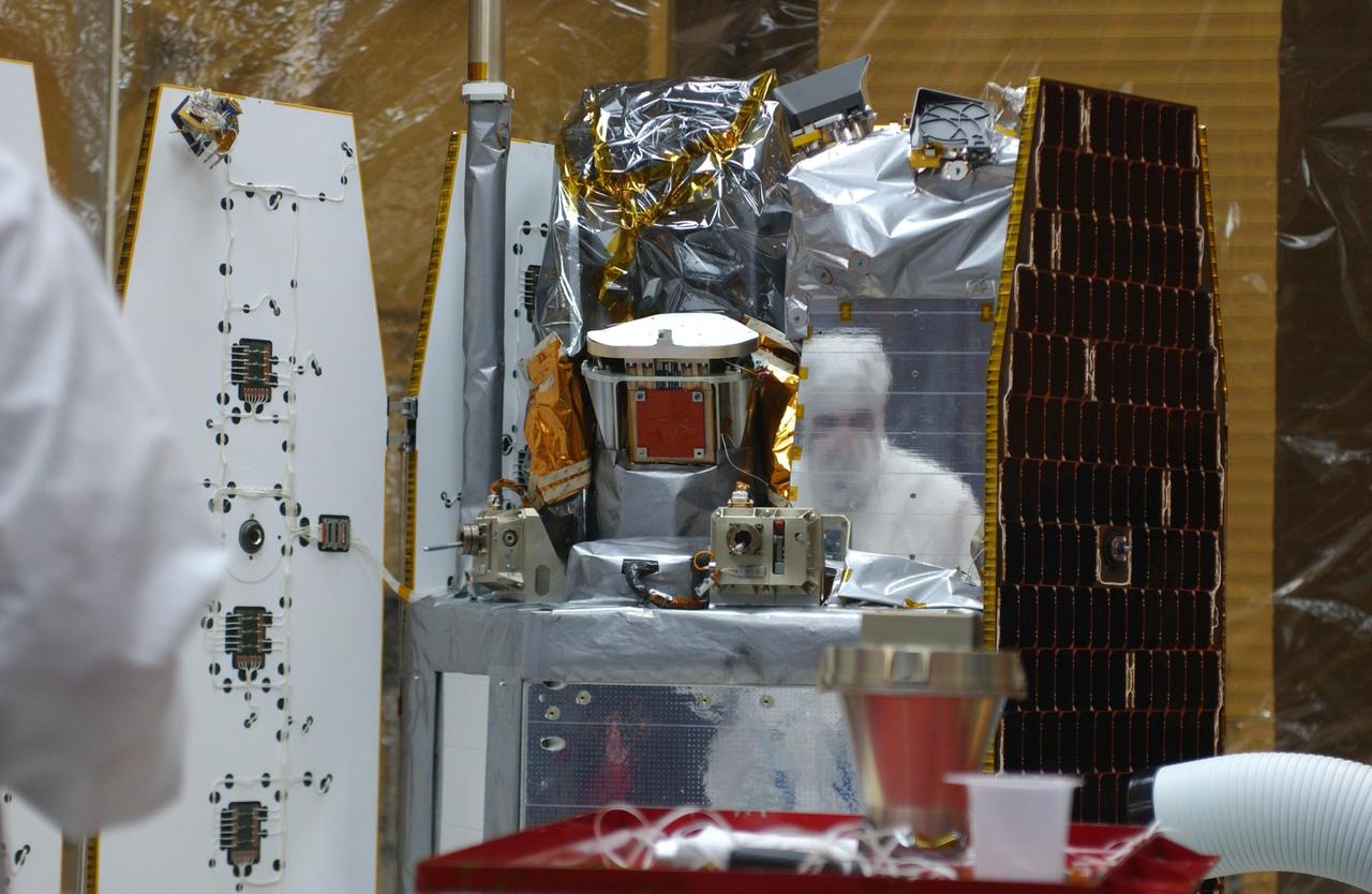 VANDENBERG AIR FORCE BASE, CALIF.  --  Inside the clean-room "tent" of Building 1555 at North Vandenberg Air Force Base, two of the solar array panels on the AIM spacecraft are deployed for testing. Inside are the instruments that will study polar mesospheric clouds located at the edge of space. The AIM spacecraft will fly three instruments designed to study those clouds located at the edge of space, 50 miles above the Earth's surface in the coldest part of the planet's atmosphere. The mission's primary goal is to explain why these clouds form and what has caused them to become brighter and more numerous and appear at lower latitudes in recent years. AIM's results will provide the basis for the study of long-term variability in the mesospheric climate and its relationship to global climate change. AIM is scheduled to be mated to the Pegasus XL during the second week of April, after which final inspections will be conducted.  Launch is scheduled for April 25.
