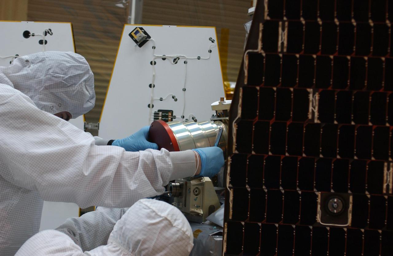KENNEDY SPACE CENTER, FLA.  --  Inside the clean-room "tent" of Building 1555 at North Vandenberg Air Force Base, technicians place a star tracker cover on the AIM spacecraft during testing of the solar array panel deployment. The AIM spacecraft will fly three instruments designed to study polar mesospheric clouds located at the edge of space, 50 miles above the Earth's surface in the coldest part of the planet's atmosphere. The mission's primary goal is to explain why these clouds form and what has caused them to become brighter and more numerous and appear at lower latitudes in recent years. AIM's results will provide the basis for the study of long-term variability in the mesospheric climate and its relationship to global climate change. AIM is scheduled to be mated to its launch vehicle, Orbital Sciences' Pegasus XL, during the second week of April, after which final inspections will be conducted.  Launch is scheduled for April 25.
