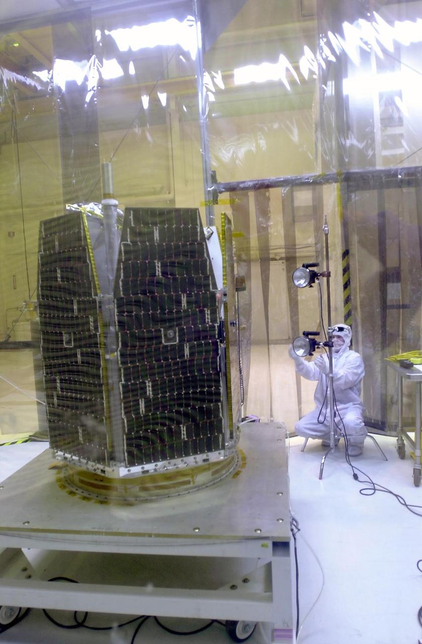 VANDENBERG AIR FORCE BASE, CALIF.  --   In a clean-room environment at North Vandenberg Air Force Base, a technician prepares the lights for illumination testing of the AIM spacecraft at left.  The AIM spacecraft will fly three instruments designed to study those clouds located at the edge of space, 50 miles above the Earth's surface in the coldest part of the planet's atmosphere. The mission's primary goal is to explain why these clouds form and what has caused them to become brighter and more numerous and appear at lower latitudes in recent years. AIM's results will provide the basis for the study of long-term variability in the mesospheric climate and its relationship to global climate change. AIM is scheduled to be mated to the Pegasus XL during the second week of April, after which final inspections will be conducted.  Launch is scheduled for April 25.