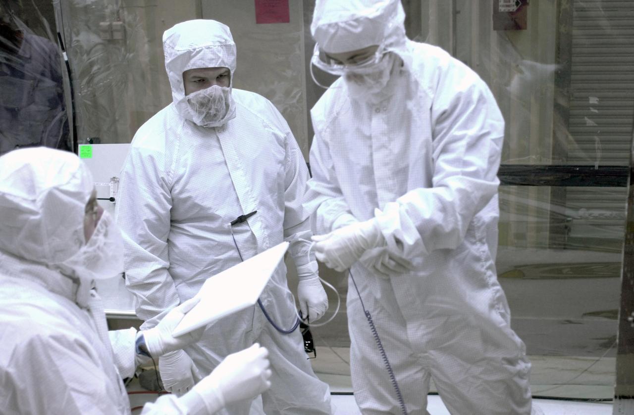 VANDENBERG AIR FORCE BASE, CALIF. -- In a clean-room environment at North Vandenberg Air Force Base, technicians look at part of the AIM spacecraft. AIM will fly three instruments designed to study polar mesospheric clouds located at the edge of space, 50 miles above the Earth's surface in the coldest part of the planet's atmosphere. The mission's primary goal is to explain why these clouds form and what has caused them to become brighter and more numerous and appear at lower latitudes in recent years. AIM's results will provide the basis for the study of long-term variability in the mesospheric climate and its relationship to global climate change. AIM is scheduled to be mated to the Pegasus XL during the second week of April, after which final inspections will be conducted. Launch is scheduled for April 25.
