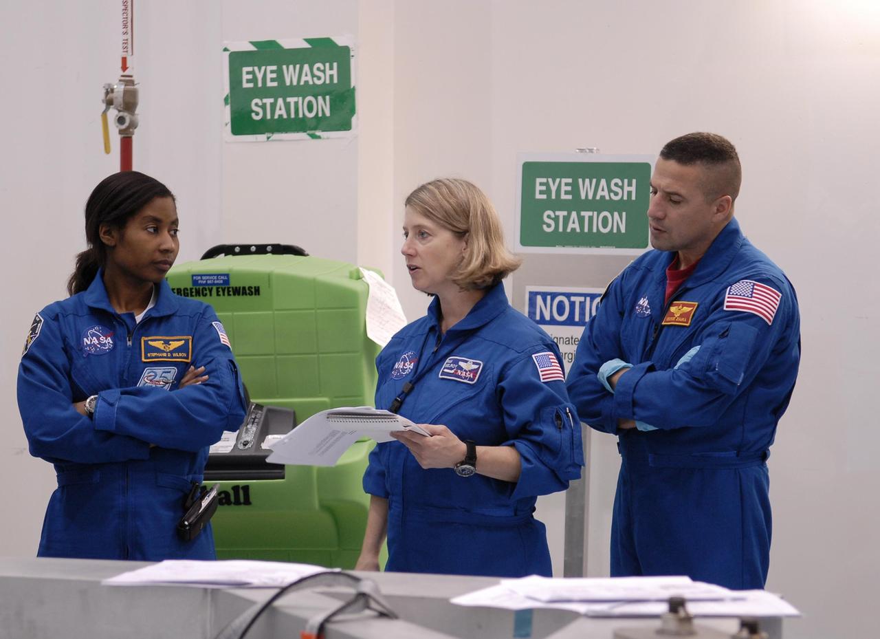 KENNEDY SPACE CENTER, FLA. --  During a familiarization visit to the Space Station Processing Facility, mission STS-120 Mission Specialist Stephanie Wilson, Commander Pam Melroy and Pilot George Zamka review safety procedures. Other STS-120 crew members include Mission Specialists Scott Parazynski, Douglas Wheelock, Daniel Tani, Paolo Nespoli (with the European Space Agency) and Clayton Anderson. Mission STS-120 will deliver the Node 2 "Harmony" connecting module to the station. During the mission, Tani and Anderson will transfer to the station and remain as flight engineers for Expedition 15. The mission is tentatively scheduled for August of this year. Photo credit: NASA/Kim Shiflett