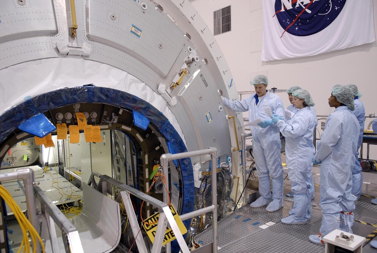 KENNEDY SPACE CENTER, FLA. -- Inside the Space Station Processing Facility, mission STS-120 crew members familiarize themselves with the Node 2 Harmony module during a visit to Kennedy Space Center. From left are Mission Specialist Scott Parazynski, Commander Pam Melroy and Mission Specialist Stephanie Wilson. Other crew members include Pilot George Zamka and Mission Specialists Douglas Wheelock, Paoli Nespoli (with the European Space Agency), Daniel Tani and Clayton Anderson. Mission STS-120 will deliver the Node 2 "Harmony" connecting module to the station.  During the mission, Tani and Anderson will transfer to the station and remain as flight engineers for Expedition 15. The mission is tentatively scheduled for August of this year. Photo credit: NASA/Kim Shiflett