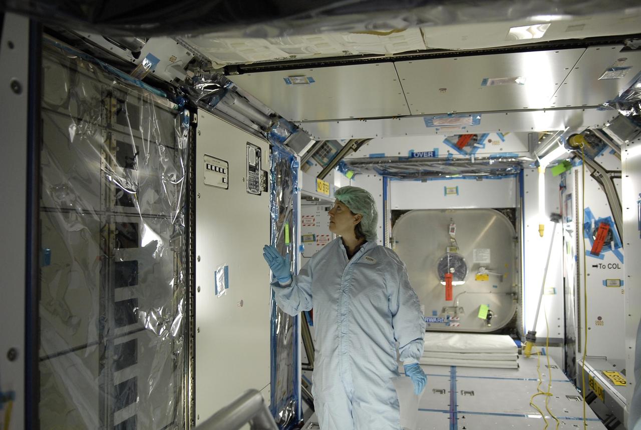 KENNEDY SPACE CENTER, FLA. -- Inside the Space Station Processing Facility, mission STS-120 Commander Pam Melroy stands inside the Node 2 Harmony module to familiarize herself with equipment during a visit to Kennedy Space Center. Other STS-120 crew members include Pilot George Zamka and Mission Specialists Scott Parazynski, Douglas Wheelock, Stephanie Wilson, Paolo Nespoli (with the European Space Agency), Daniel Tani and Clayton Anderson. Mission STS-120 will deliver the Node 2 "Harmony" connecting module to the station.  During the mission, Tani and Anderson will transfer to the station and remain as flight engineers for Expedition 15. The mission is tentatively scheduled for August of this year. Photo credit: NASA/Kim Shiflett