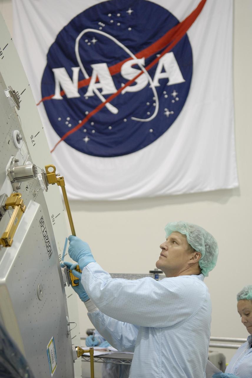 KENNEDY SPACE CENTER, FLA. -- With the NASA logo serving as a backdrop, STS-120 Mission Specialist Scott Parazynski familiarizes himself with equipment inside the Space Station Processing Facility during a visit to Kennedy Space Center. Other crew members include Commander Pam Melroy, Pilot George Zamka, and Mission Specialists Douglas Wheelock, Stephanie Wilson, Daniel Tani, Paolo Nespoli (with the European Space Agency) and Clayton Anderson.  Mission STS-120 will deliver the Node 2 "Harmony" connecting module to the station.  During the mission, Tani and Anderson will transfer to the station and remain as flight engineers for Expedition 15. The mission is tentatively scheduled for August of this year. Photo credit: NASA/Kim Shiflett
