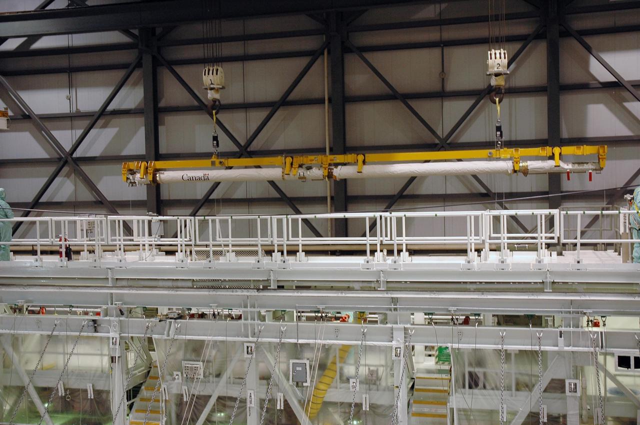 KENNEDY SPACE CENTER, FLA. -- In Orbiter Processing Facility bay 2, the orbiter boom sensor system is lifted above the work platforms prior to installation in Endeavour. The orbiter is scheduled to fly on mission STS-118 to the International Space Station in the summer of 2007. It will deliver the third starboard truss segment, S5. Photo credit: NASA/Troy Cryder