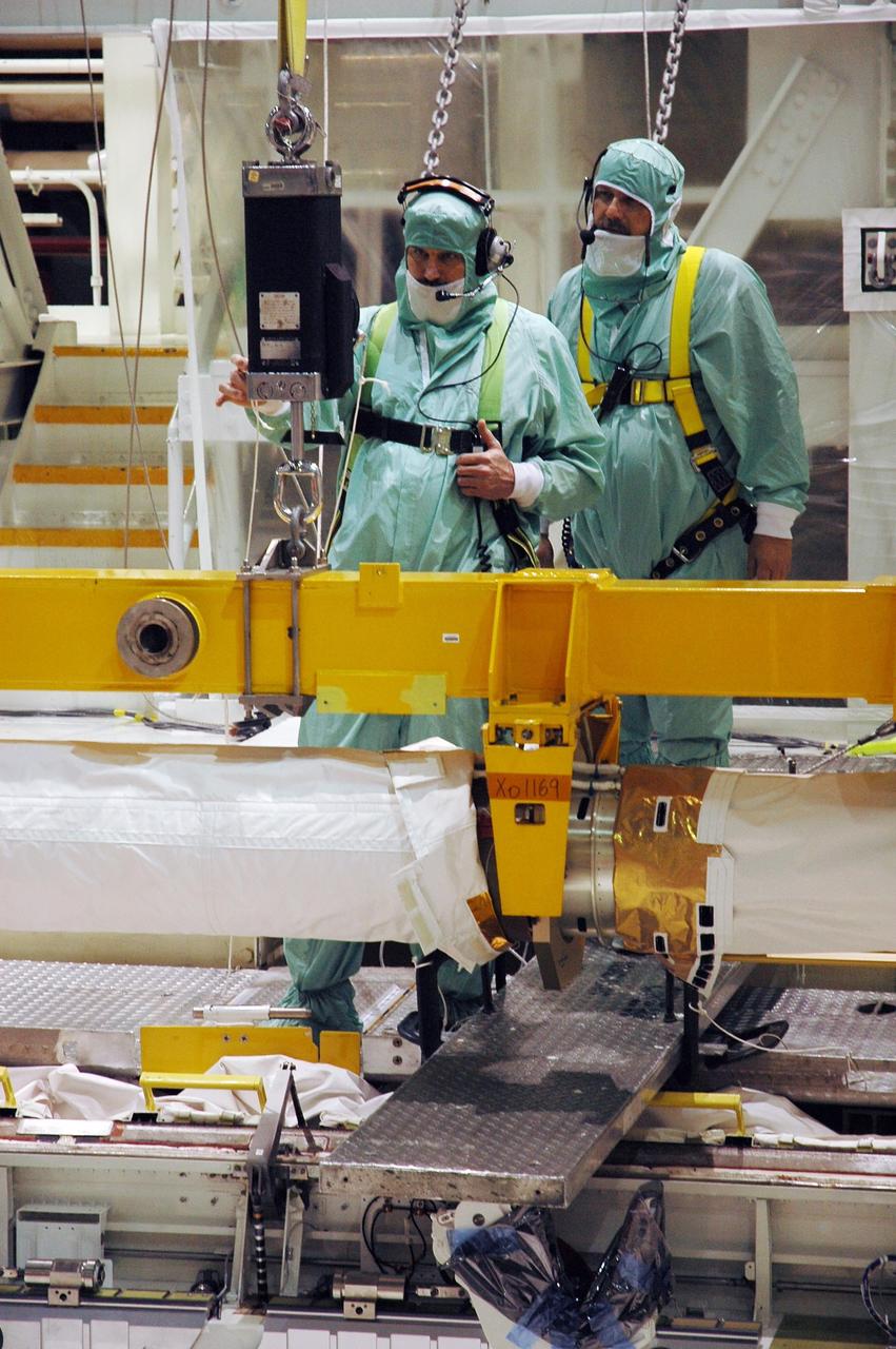 KENNEDY SPACE CENTER, FLA.  --  In Orbiter Processing Facility bay 2, workers monitor the placement of the orbiter boom sensor system in Endeavour's payload bay.  The orbiter is scheduled to fly on mission STS-118 to the International Space Station in the summer of 2007.  It will deliver the third starboard truss segment, S5.  Photo credit: NASA/Troy Cryder