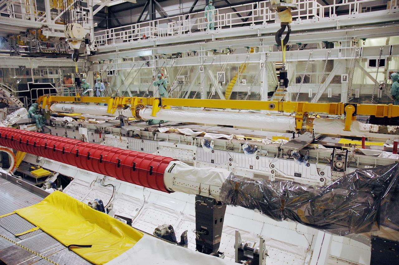 KENNEDY SPACE CENTER, FLA. -- In Orbiter Processing Facility bay 2, workers secure the orbiter boom sensor system in Endeavour's payload bay. The orbiter is scheduled to fly on mission STS-118 to the International Space Station in the summer of 2007. It will deliver the third starboard truss segment, S5. Photo credit: NASA/Troy Cryder