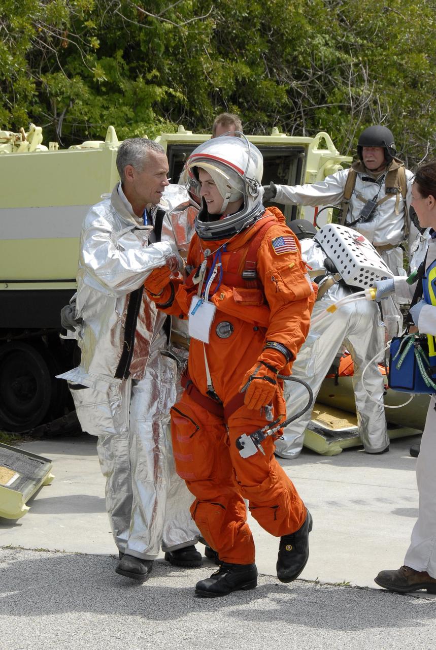 KENNEDY SPACE CENTER, FLA. -- During the second stage of a simulated emergency, known as Mode 4, KSC personnel representing astronauts are treated at a triage area set up at Helipad 8, located near the fire station between Launch Pads 39A and 39B. The emergency exercise began on Launch Pad 39A. The participants were helped off the pad and taken to the triage site. The "injured" workers will be airlifted to participating area hospitals. The KSC rescue teams are practicing emergency procedures in the unlikely scenario of a mishap on the pad during a launch sequence. The exercises are standard training procedures to assess and prepare emergency personnel, procedures and hardware. Photo credit: NASA/Kim Shiflett