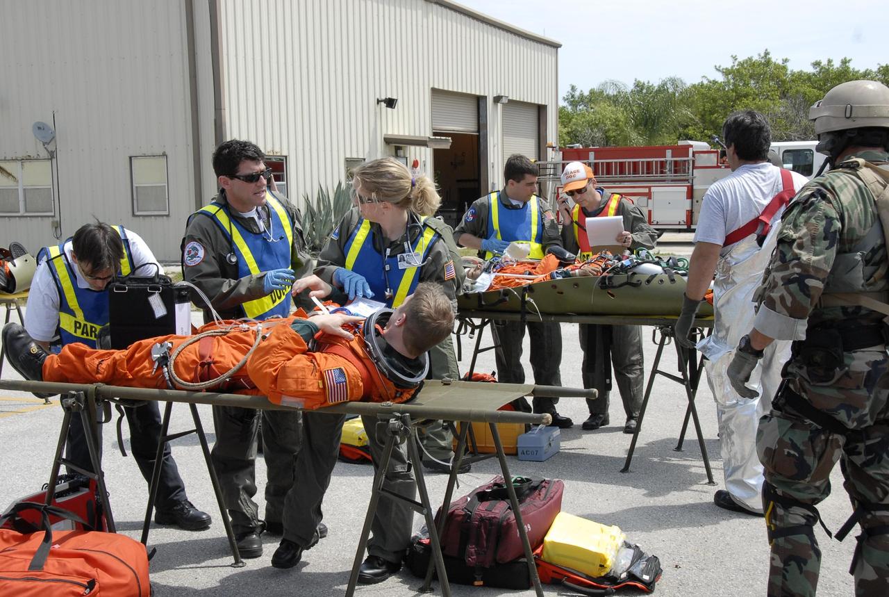 KENNEDY SPACE CENTER, FLA. -- During the second stage of a simulated emergency, known as Mode 4, a triage area set up at Helipad 8, located near the fire station between Launch Pads 39A and 39B, is busy as rescue workers monitor the "injured." KSC personnel portrayed the astronauts. The participants were helped off the pad and taken to the triage site. The "injured" worker may be airlifted to participating area hospitals. The KSC rescue teams are practicing emergency procedures in the unlikely scenario of a mishap on the pad during a launch sequence. The exercises are standard training procedures to assess and prepare emergency personnel, procedures and hardware. Photo credit: NASA/Kim Shiflett