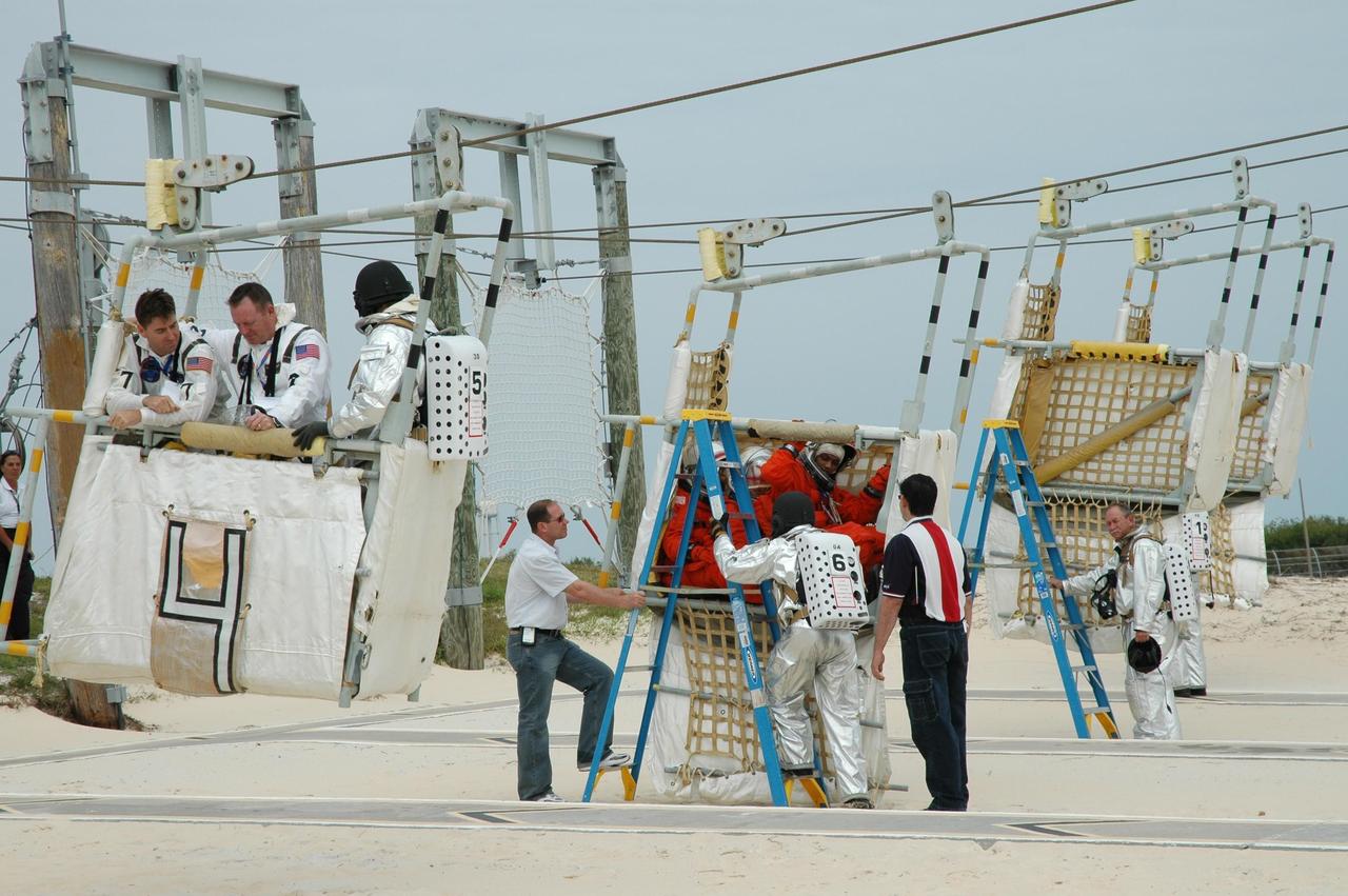 KENNEDY SPACE CENTER, FLA.  -- During the second stage of a simulated emergency, known as Mode 4,  KSC personnel dressed in astronauts' launch-and-entry suits are helped by the fire rescue team at the slidewire basket landing site. The emergency exercise began at the 195-foot level of Launch Pad 39A. The KSC rescue teams are practicing emergency procedures in the unlikely scenario of a mishap on the pad during a launch sequence.  The exercises are standard training procedures to assess and prepare emergency personnel, procedures and hardware.  Photo credit: NASA/Jim Grossmann