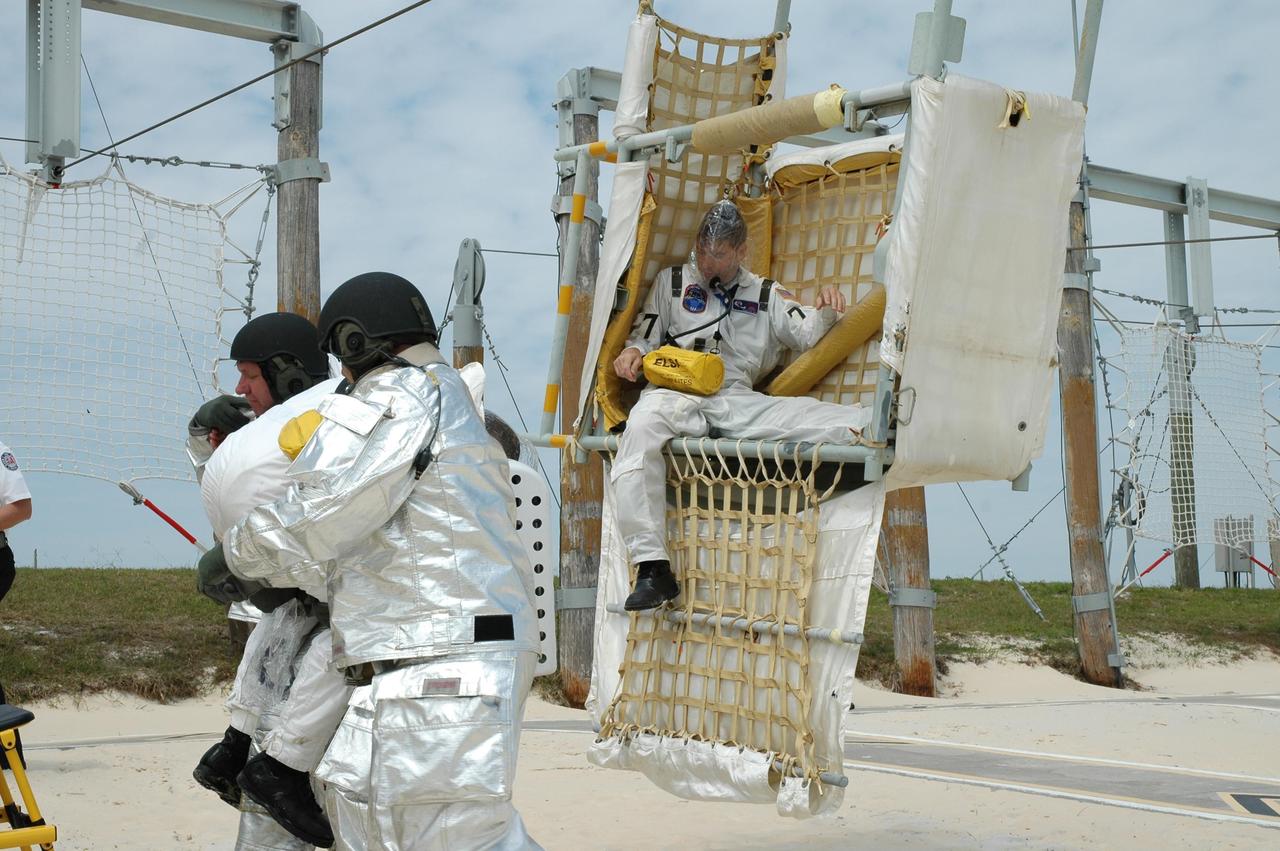 KENNEDY SPACE CENTER, FLA.  -- During the second stage of a simulated emergency, known as Mode 4,  part of the KSC fire rescue team helps "injured" members of the closeout crew out of the slidewire baskets.  The emergency exercise began at the 195-foot level of Launch Pad 39A.  The KSC rescue teams are practicing emergency procedures in the unlikely scenario of a mishap on the pad during a launch sequence.  The exercises are standard training procedures to assess and prepare emergency personnel, procedures and hardware.  Photo credit: NASA/Jim Grossmann