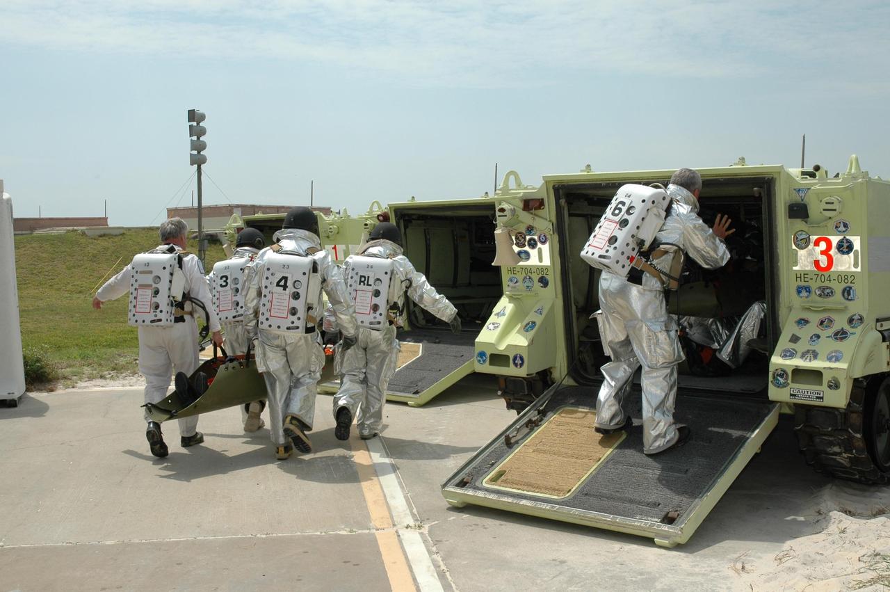 KENNEDY SPACE CENTER, FLA. -- During the second stage of a simulated emergency, known as Mode 4, the KSC rescue team moves "injured" astronauts, portrayed by KSC personnel, into M-113 armored carriers. The M-113 will be used to transport the workers to a triage area. The emergency exercise began at the 195-foot level of Launch Pad 39A. The KSC rescue teams are practicing emergency procedures in the unlikely scenario of a mishap on the pad during a launch sequence. The exercises are standard training procedures to assess and prepare emergency personnel, procedures and hardware. Photo credit: NASA/Jim Grossmann