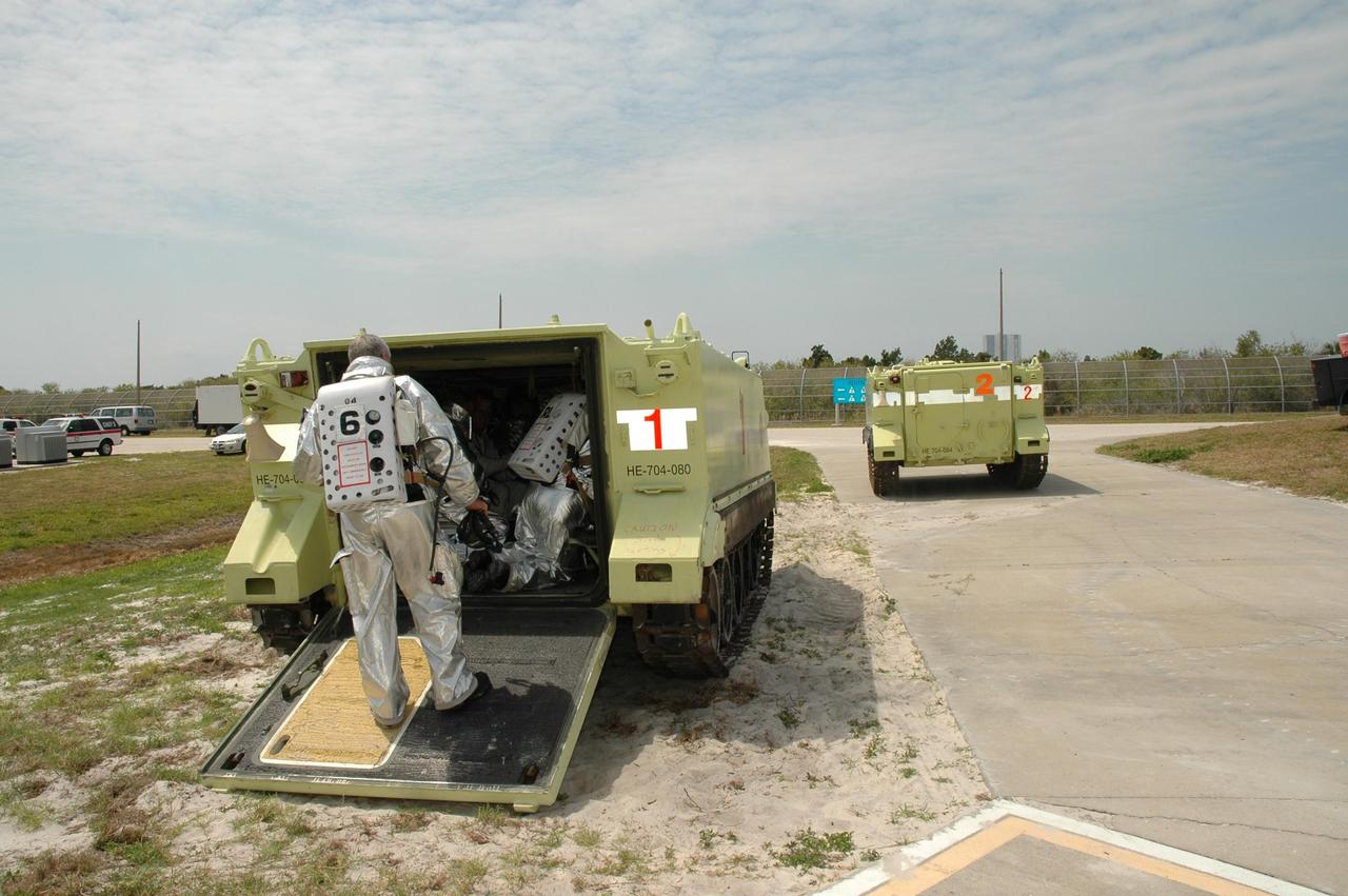 KENNEDY SPACE CENTER, FLA. -- During the second stage of a simulated emergency, known as Mode 4, one M-113 armored carrier leaves Launch Pad 39A while a second waits for another passenger. The carriers are being used to transport workers simulating astronauts and others to a triage area. The emergency exercise began at the 195-foot level of Launch Pad 39A. The KSC rescue teams are practicing emergency procedures in the unlikely scenario of a mishap on the pad during a launch sequence. The exercises are standard training procedures to assess and prepare emergency personnel, procedures and hardware. Photo credit: NASA/Jim Grossmann