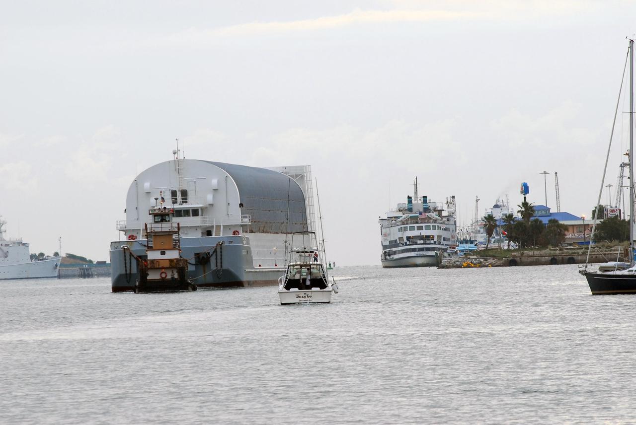 KENNEDY SPACE CENTER, FLA. -- The Pegasus barge, with its cargo of the external tank prepared for mission STS-118, moves toward the upraised Banana River bridge. The barge is being towed to the turn basin near the Vehicle Assembly Building where the tank will be offloaded and moved to the VAB. Photo credit: Jack Pfaller