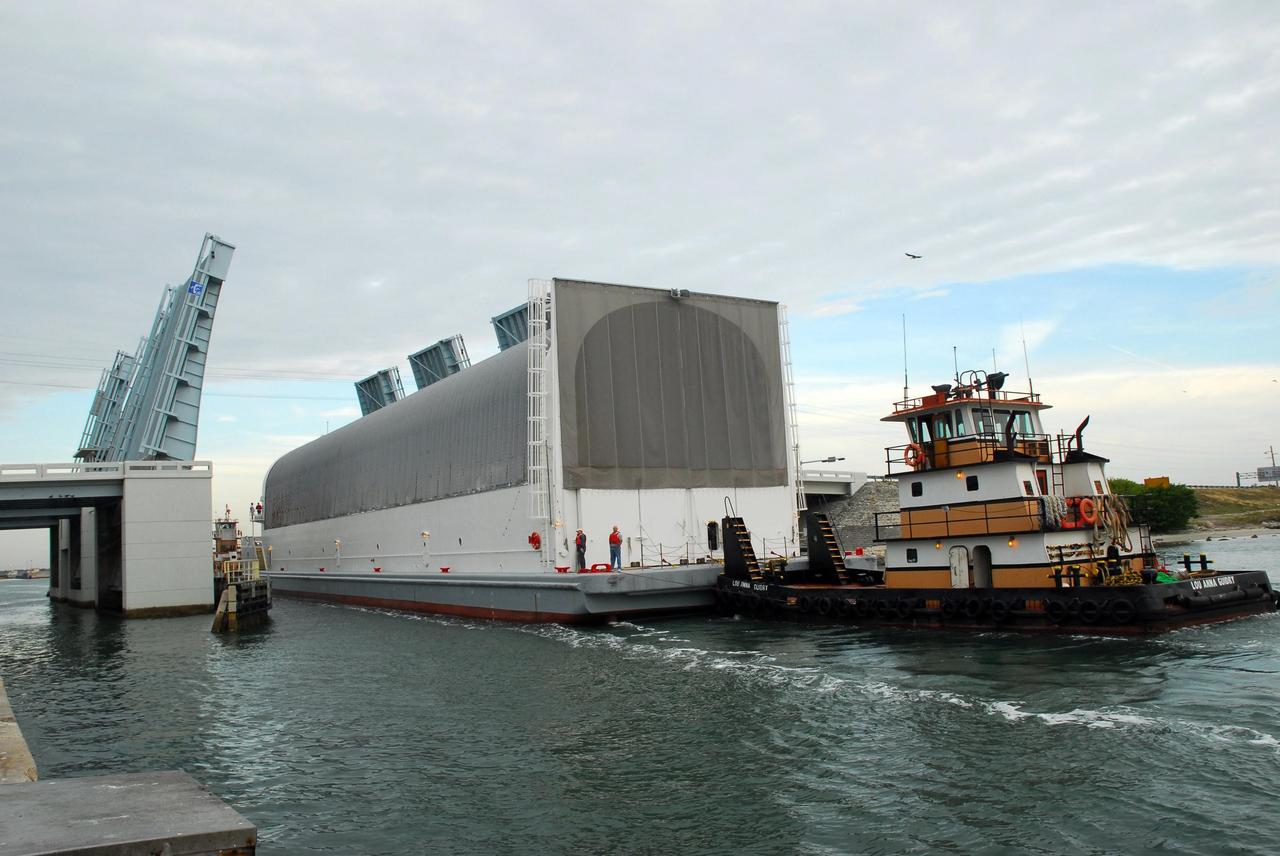 KENNEDY SPACE CENTER, FLA. -- The Pegasus barge, with its cargo of the external tank prepared for mission STS-118, moves through the upraised Banana River bridge. The barge is being towed to the turn basin near the Vehicle Assembly Building where the tank will be offloaded and moved to the VAB. Photo credit: Jack Pfaller