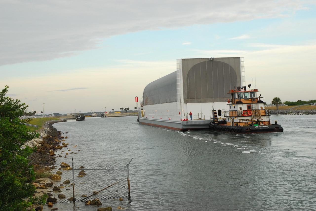 KENNEDY SPACE CENTER, FLA. -- After passing through the Banana River bridge, the Pegasus barge, with its cargo of the external tank prepared for mission STS-118, is towed upriver to the turn basin near the Vehicle Assembly Building. There the tank will be offloaded and moved to the VAB. Photo credit: Jack Pfaller