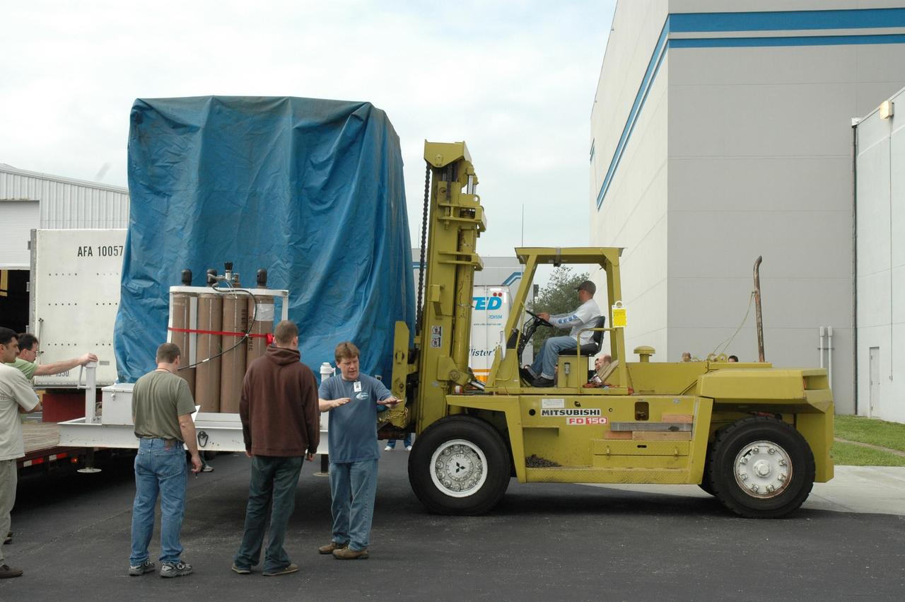 KENNEDY SPACE CENTER, FLA.  -- At Astrotech, the shipping container holding the Dawn spacecraft is removed from the truck.  The container will then be moved into the high bay of the Payload Processing Facility and the spacecraft removed.  Dawn's mission is to explore two of the asteroid belt's most intriguing and dissimilar occupants: asteroid Vesta and the dwarf planet Ceres.  The Dawn mission is managed by JPL, a division of the California Institute of Technology in Pasadena, for NASA's Science Mission Directorate in Washington, D.C.   Photo credit: NASA/Jim Grossmann
