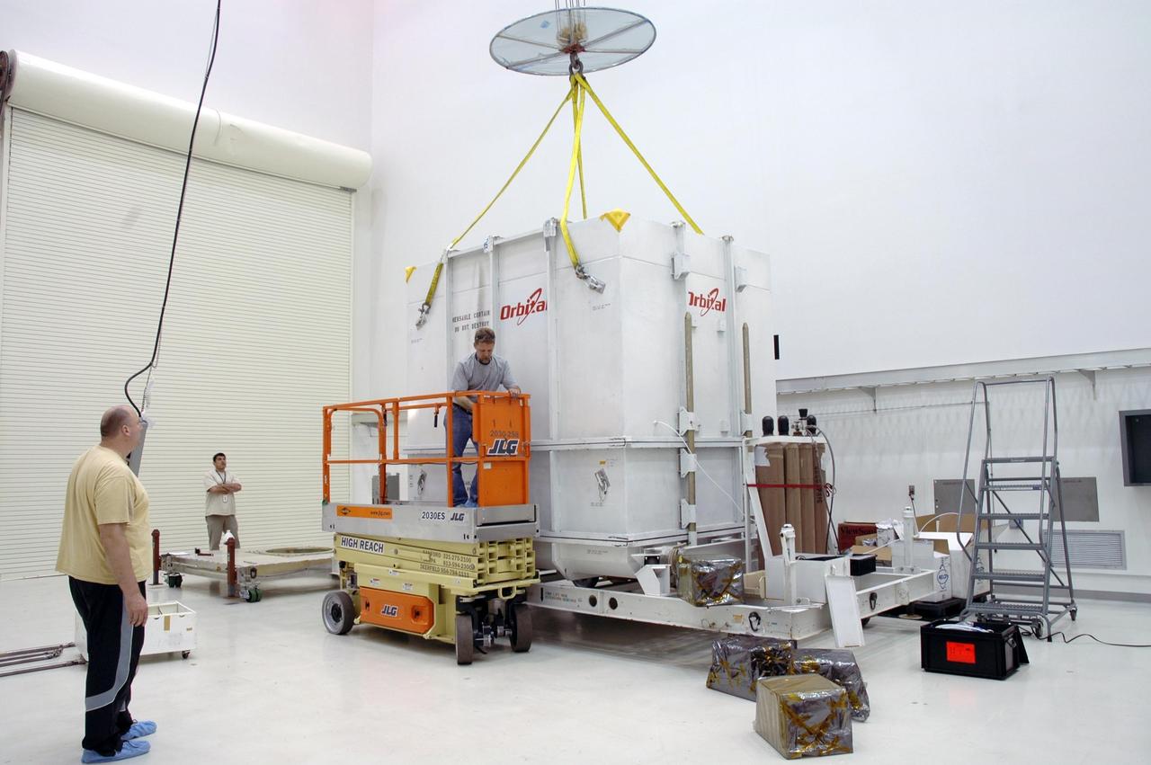 KENNEDY SPACE CENTER, FLA.  -- In Astrotech's Payload Processing Facility, a crane is attached to the shipping container to remove it from around the Dawn spacecraft.  Dawn's mission is to explore two of the asteroid belt's most intriguing and dissimilar occupants: asteroid Vesta and the dwarf planet Ceres.  The Dawn mission is managed by JPL, a division of the California Institute of Technology in Pasadena, for NASA's Science Mission Directorate in Washington, D.C.   Photo credit: NASA/Jim Grossmann