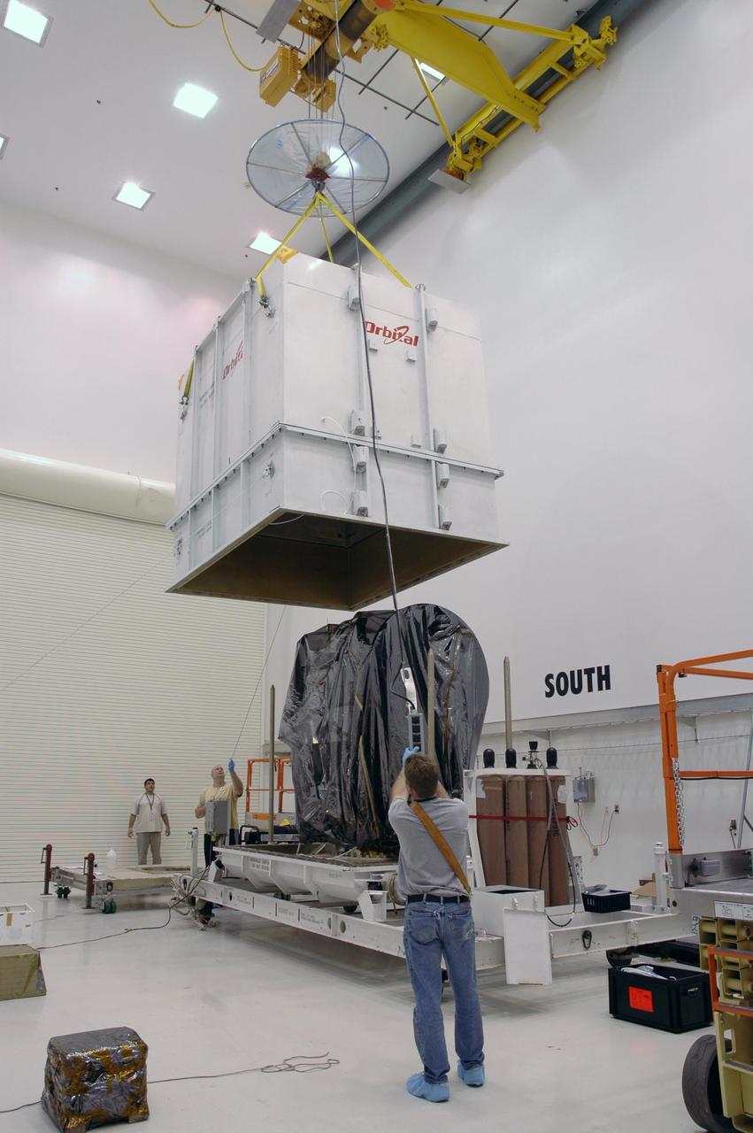 KENNEDY SPACE CENTER, FLA.  -- In Astrotech's Payload Processing Facility, a crane lifts the shipping container from the Dawn spacecraft.  Dawn's mission is to explore two of the asteroid belt's most intriguing and dissimilar occupants: asteroid Vesta and the dwarf planet Ceres.  The Dawn mission is managed by JPL, a division of the California Institute of Technology in Pasadena, for NASA's Science Mission Directorate in Washington, D.C.   Photo credit: NASA/Jim Grossmann