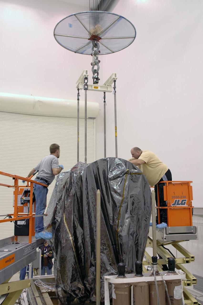 KENNEDY SPACE CENTER, FLA.  -- In Astrotech's Payload Processing Facility, a crane is being attached to the Dawn spacecraft to lift it from the transporter.   Dawn's mission is to explore two of the asteroid belt's most intriguing and dissimilar occupants: asteroid Vesta and the dwarf planet Ceres.  The Dawn mission is managed by JPL, a division of the California Institute of Technology in Pasadena, for NASA's Science Mission Directorate in Washington, D.C.   Photo credit: NASA/Jim Grossmann