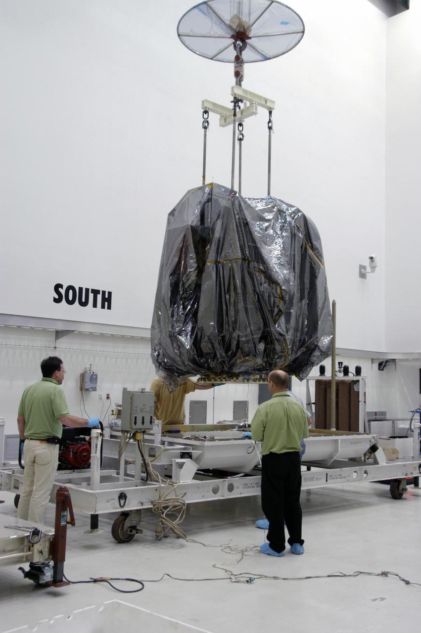KENNEDY SPACE CENTER, FLA.  --  In Astrotech's Payload Processing Facility, an overhead crane lifts the Dawn spacecraft from its transporter.  Dawn will be moved into clean room C for unbagging and further processing.   Dawn's mission is to explore two of the asteroid belt's most intriguing and dissimilar occupants: asteroid Vesta and the dwarf planet Ceres.  The Dawn mission is managed by JPL, a division of the California Institute of Technology in Pasadena, for NASA's Science Mission Directorate in Washington, D.C.   Photo credit: NASA/George Shelton