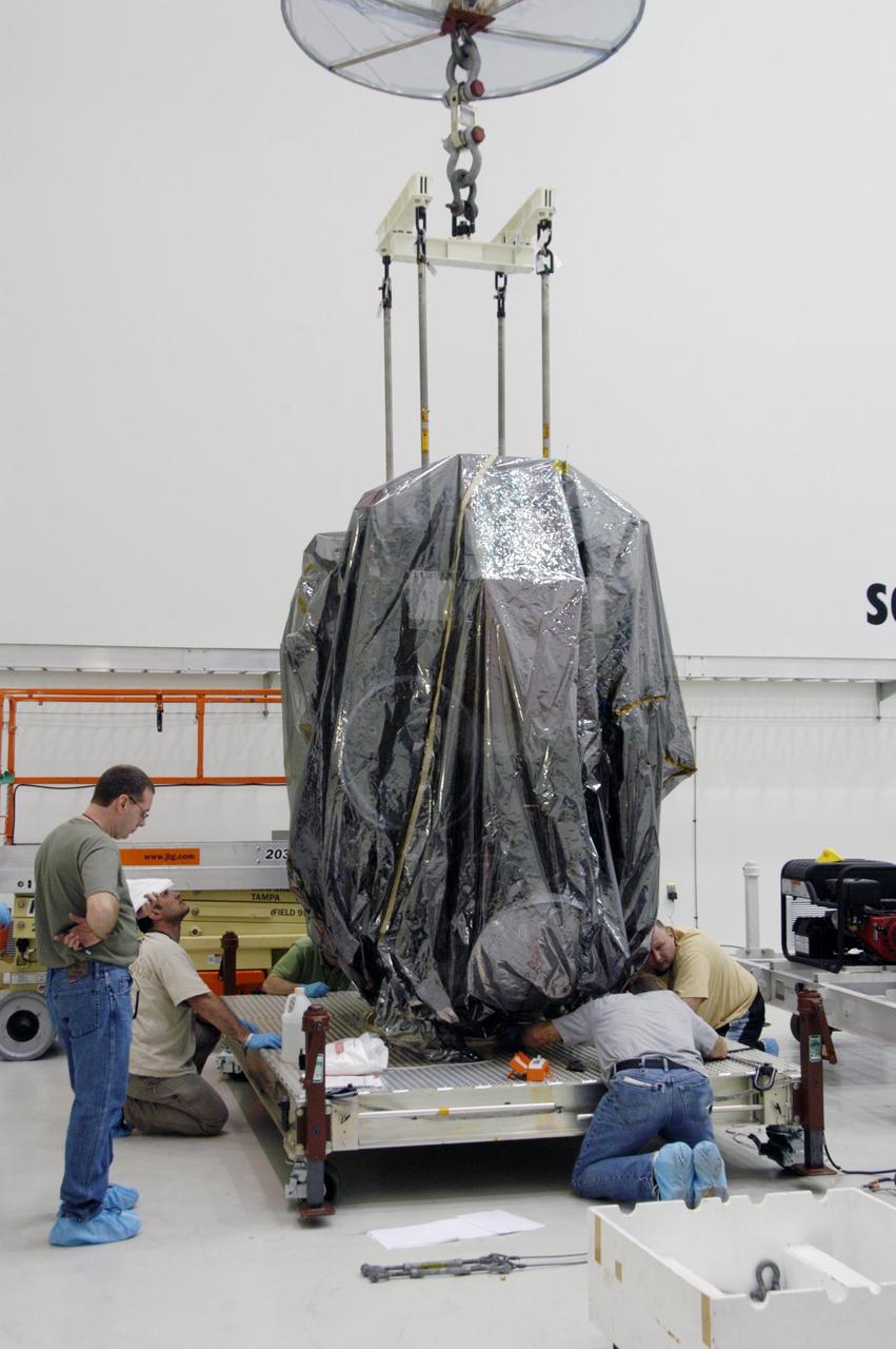 KENNEDY SPACE CENTER, FLA.  --  In Astrotech's Payload Processing Facility, technicians help secure the Dawn spacecraft onto a moveable stand.  Dawn will be moved into clean room C for unbagging and further processing.  Dawn's mission is to explore two of the asteroid belt's most intriguing and dissimilar occupants: asteroid Vesta and the dwarf planet Ceres.  The Dawn mission is managed by JPL, a division of the California Institute of Technology in Pasadena, for NASA's Science Mission Directorate in Washington, D.C.   Photo credit: NASA/George Shelton