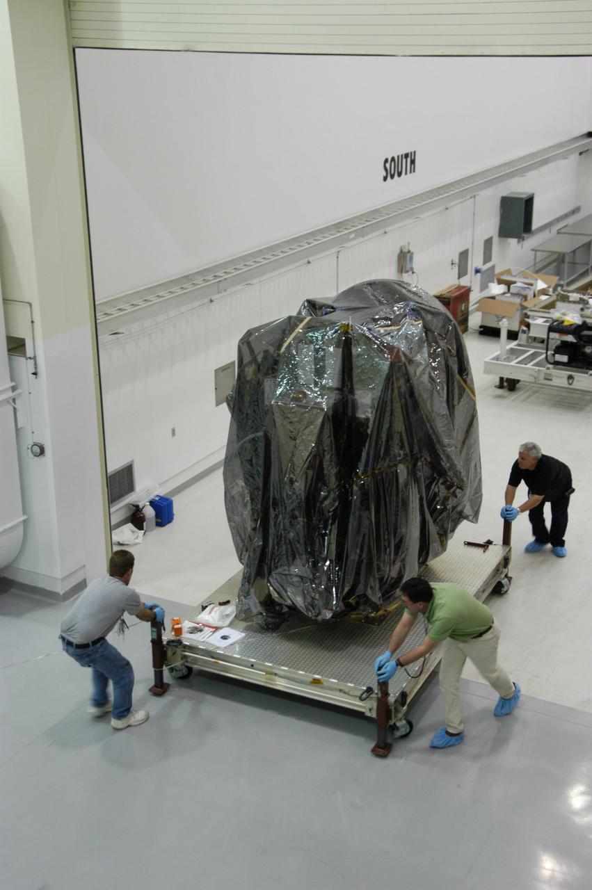KENNEDY SPACE CENTER, FLA.  --  In Astrotech's Payload Processing Facility, technicians roll the Dawn spacecraft into clean room C for unbagging and further processing. Dawn's mission is to explore two of the asteroid belt's most intriguing and dissimilar occupants: asteroid Vesta and the dwarf planet Ceres.  The Dawn mission is managed by JPL, a division of the California Institute of Technology in Pasadena, for NASA's Science Mission Directorate in Washington, D.C.   Photo credit: NASA/George Shelton