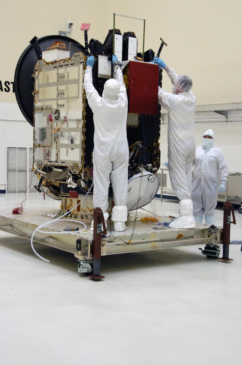 KENNEDY SPACE CENTER, FLA.  -- In clean room C of Astrotech's Payload Processing Facility, technicians dressed in "bunny suits," or clean-room attire, begin working on the Dawn spacecraft. Dawn's mission is to explore two of the asteroid belt's most intriguing and dissimilar occupants: asteroid Vesta and the dwarf planet Ceres.  The Dawn mission is managed by JPL, a division of the California Institute of Technology in Pasadena, for NASA's Science Mission Directorate in Washington, D.C.   Photo credit: NASA/George Shelton