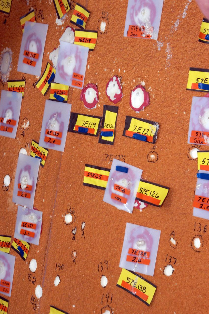 KENNEDY SPACE CENTER, FLA.  --   In the Vehicle Assembly Building, markers show the hail damage being repaired on the external tank of Space Shuttle Atlantis.  The white hole with a red circle around it is a hole prepared for molding and material application. The red material is sealant tape so the mold doesn't leak when the foam rises against the mold. The white/translucent square mold is an area where the foam has been applied and the foam has risen and cured against the mold surface. The area will be de-molded and sanded flush with the adjacent area.  In late February, Atlantis' external tank received hail damage during a severe thunderstorm that passed through the Kennedy Space Center Launch Complex 39 area. The hail caused visible divots in the giant tank's foam insulation as well as minor surface damage to about 26 heat shield tiles on the shuttle's left wing.  The launch now is targeted for June 8.  Photo credit: NASA/George Shelton