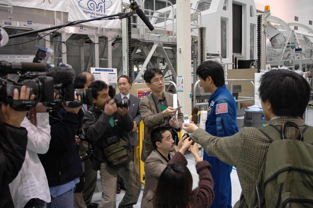 KENNEDY SPACE CENTER, FLA.  --   In the Space Station Processing Facility, journalists and photographers ask Japanese astronaut Takao Doi about the Experiment Logistics Module Pressurized Section for the Japanese Experiment Module, or JEM, that he will accompany on mission STS-123 to the International Space Station.  Earlier, NASA and Japanese Aerospace and Exploration Agency (JAXA) officials welcomed the arrival of the logistics module. The logistics module will serve as an on-orbit storage area for materials, tools and supplies. It can hold up to eight experiment racks and will attach to the top of another larger pressurized module.  Photo credit: NASA/George Shelton