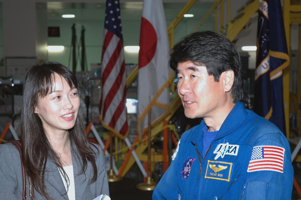 KENNEDY SPACE CENTER, FLA.  --  After a welcoming ceremony for the Experiment Logistics Module Pressurized Section of the Japanese Experiment Module, astronaut Takao Doi (right) talks with Kumiko Tanabe, a public affairs representative of the Japanese Aerospace and Exploration Agency.  The logistics module will be delivered to the space station on mission STS-123.  Doi is a crew member on that mission.The module will serve as an on-orbit storage area for materials, tools and supplies. It can hold up to eight experiment racks and will attach to the top of another larger pressurized module.  Photo credit: NASA/George Shelton