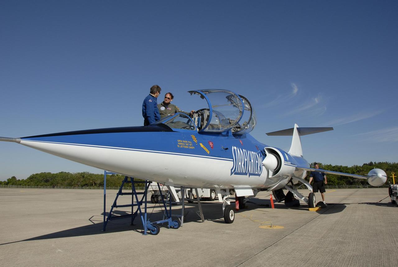 KENNEDY SPACE CENTER, FLA.  --  On the KSC Shuttle Landing Facility, a Starfighter F-104 aircraft is being prepared for test flights.  Ready to climb into the cockpit is the pilot, Rick Svetkoff. The aircraft is taking part in a series of pathfinder test missions from the space shuttle runway. Two flights will generate test data to validate sonic boom assumptions about the potential impacts of suborbital and orbital commercial spaceflight from the facility. NASA is assessing the environmental impact of such flights.  Starfighters Inc. of Clearwater, Fla., will perform the flights to help in assessing suborbital space launch trajectories from the runway and paving the way for future commercial space tourism and research flights from the facility.  Photo credit: NASA/Kim Shiflett