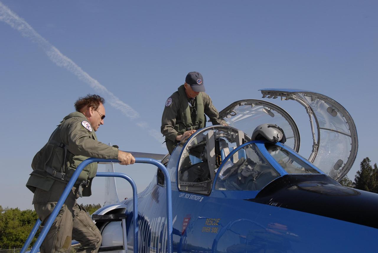 KENNEDY SPACE CENTER, FLA.  --  On the KSC Shuttle Landing Facility, pilot Rick Svetkoff (left) climbs toward the cockpit of the Starfighter F-104 while co-pilot Dave Waldrop settles in his seat. The aircraft is taking part in a series of pathfinder test missions from the space shuttle runway. Two flights will generate test data to validate sonic boom assumptions about the potential impacts of suborbital and orbital commercial spaceflight from the facility. NASA is assessing the environmental impact of such flights.  Starfighters Inc. of Clearwater, Fla., will perform the flights to help in assessing suborbital space launch trajectories from the runway and paving the way for future commercial space tourism and research flights from the facility.  Photo credit: NASA/Kim Shiflett
