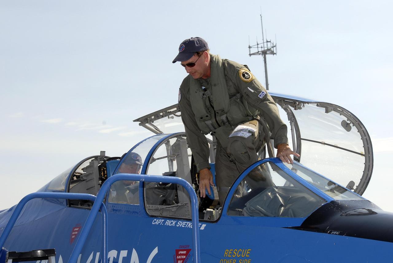KENNEDY SPACE CENTER, FLA.  --   After returning from a test flight, pilot Rick Svetkoff climbs out of the cockpit of the Starfighter F-104.   The aircraft is taking part in a series of pathfinder test missions from the space shuttle runway. Two flights will generate test data to validate sonic boom assumptions about the potential impacts of suborbital and orbital commercial spaceflight from the facility. NASA is assessing the environmental impact of such flights.  Starfighters Inc. of Clearwater, Fla., will perform the flights to help in assessing suborbital space launch trajectories from the runway and paving the way for future commercial space tourism and research flights from the facility.  Photo credit: NASA/Kim Shiflett