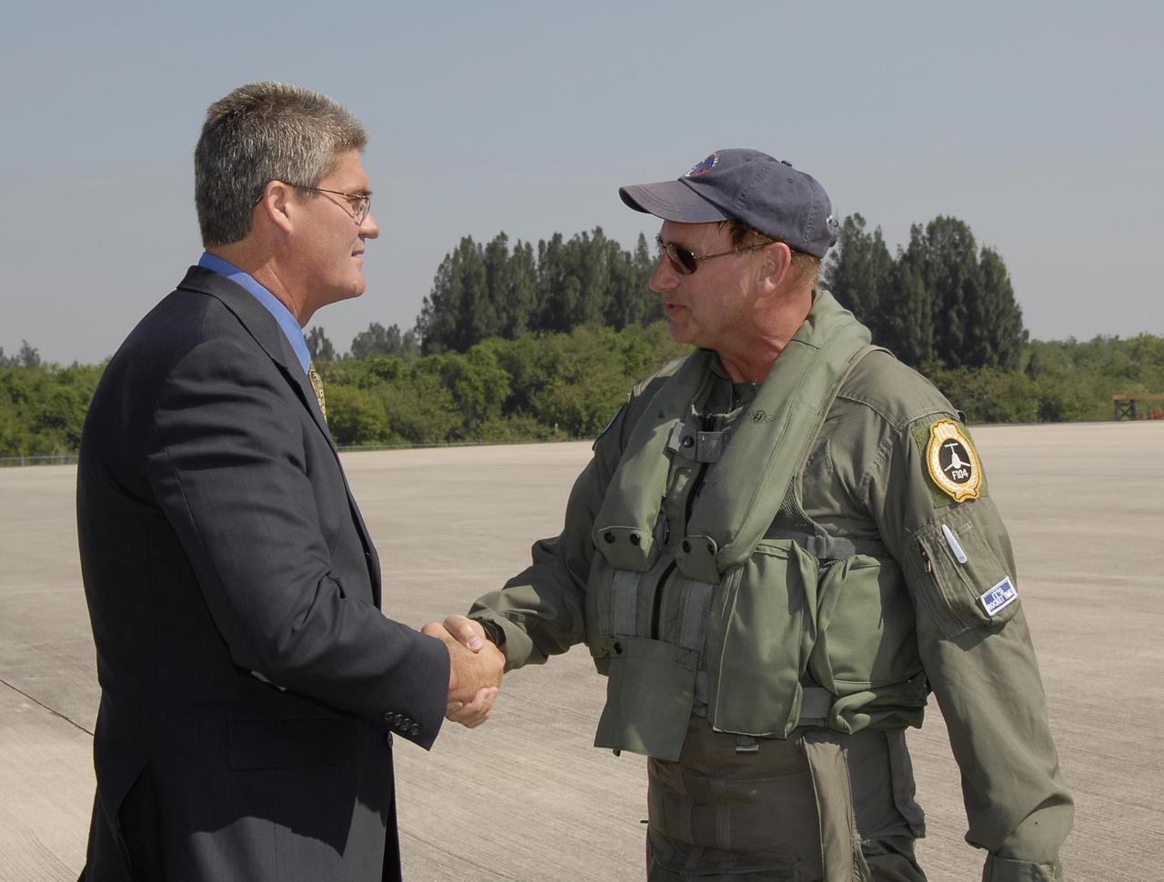 KENNEDY SPACE CENTER, FLA.  --   Bill Parsons (left), director of Kennedy Space Center, greets pilot Rick Svetkoff after a test flight of the Starfighter F-104.  The aircraft is taking part in a series of pathfinder test missions from the space shuttle runway. Two flights will generate test data to validate sonic boom assumptions about the potential impacts of suborbital and orbital commercial spaceflight from the facility. NASA is assessing the environmental impact of such flights.  Starfighters Inc. of Clearwater, Fla., will perform the flights to help in assessing suborbital space launch trajectories from the runway and paving the way for future commercial space tourism and research flights from the facility.  Photo credit: NASA/Kim Shiflett
