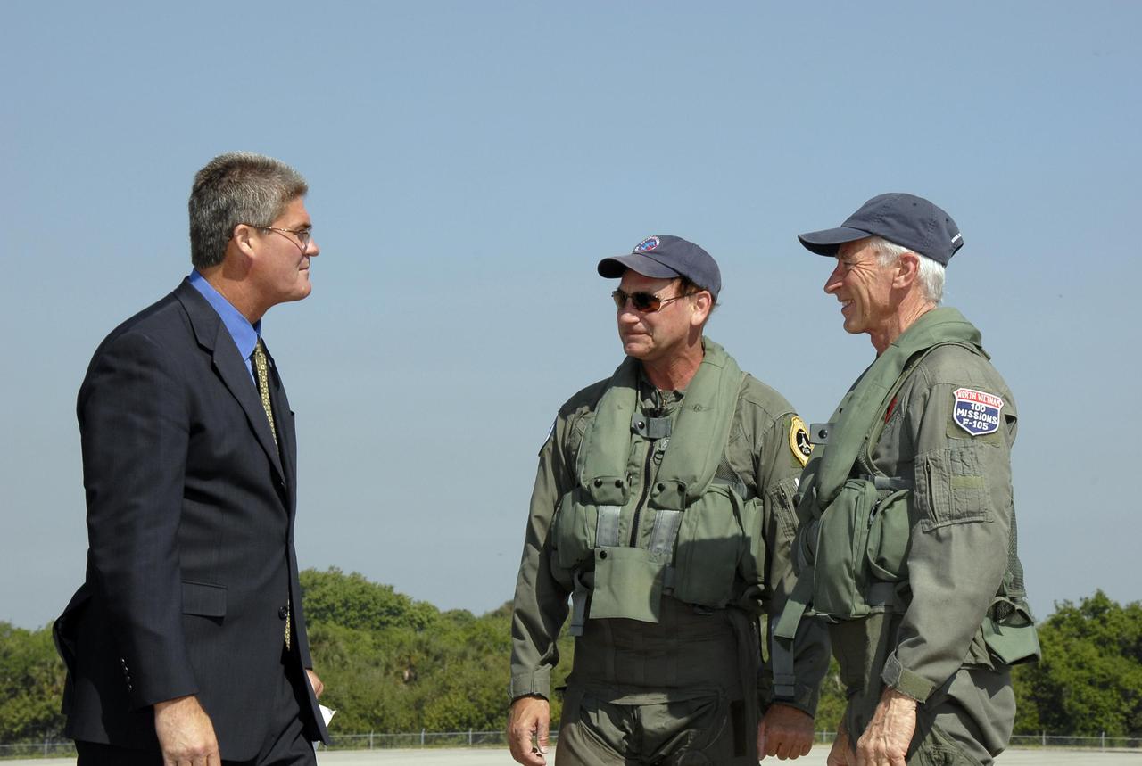 KENNEDY SPACE CENTER, FLA.  --   Bill Parsons (left), director of Kennedy Space Center, greets pilot Rick Svetkoff and co-pilot Dave Waldrop after a test flight of the Starfighter F-104. The aircraft is taking part in a series of pathfinder test missions from the space shuttle runway. Two flights will generate test data to validate sonic boom assumptions about the potential impacts of suborbital and orbital commercial spaceflight from the facility. NASA is assessing the environmental impact of such flights.  Starfighters Inc. of Clearwater, Fla., will perform the flights to help in assessing suborbital space launch trajectories from the runway and paving the way for future commercial space tourism and research flights from the facility.  Photo credit: NASA/Kim Shiflett