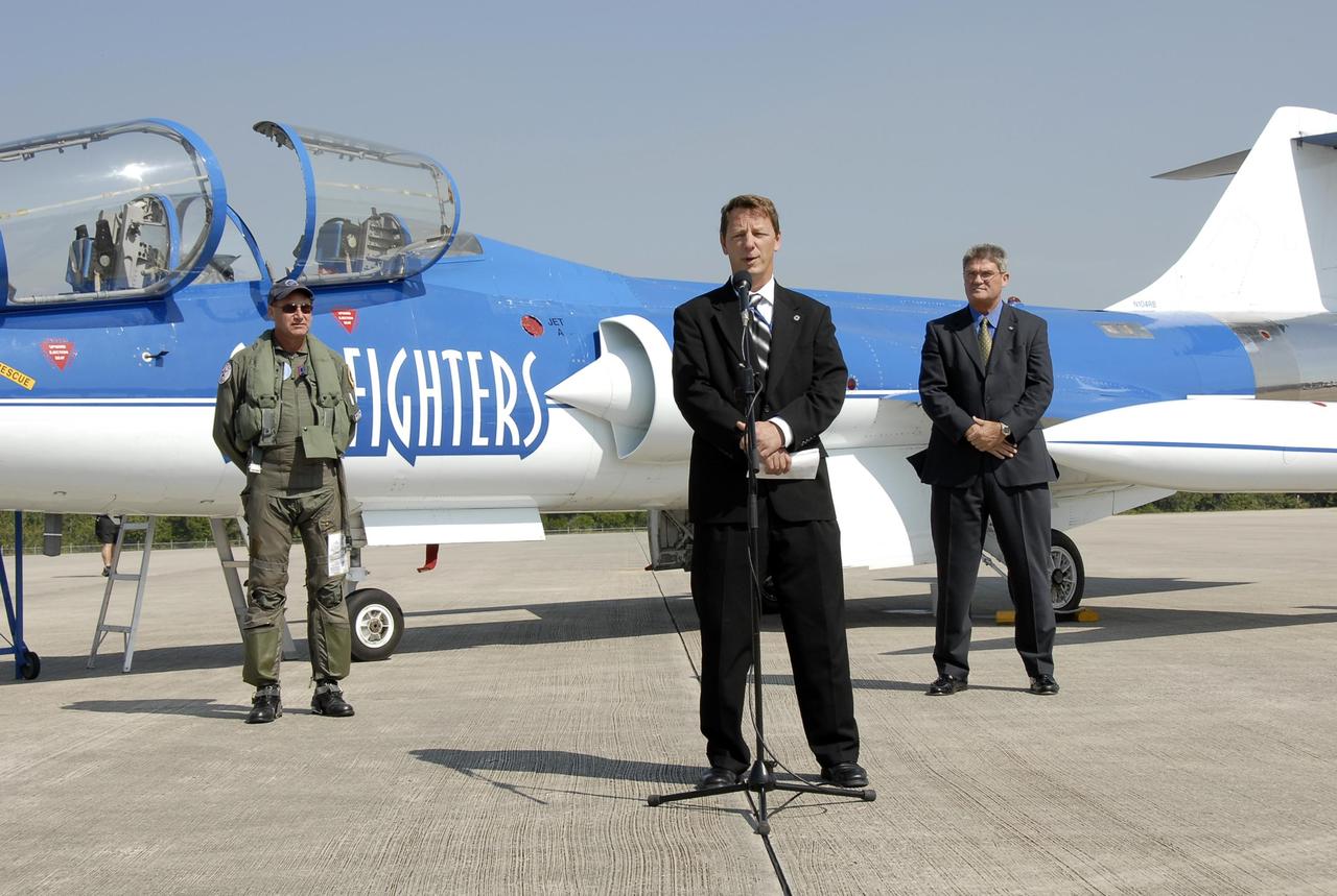 KENNEDY SPACE CENTER, FLA.  --  After a test flight of the Starfighter F-104, Al Wassel, a representative from the FAA Office of Commercial Space, addresses the media on the KSC Shuttle Landing Facility.  At left is the F-104 pilot, Rick Svetkoff.  At right is Bill Parsons, director of Kennedy Space Center.  The aircraft is taking part in a series of pathfinder test missions from the space shuttle runway. Two flights will generate test data to validate sonic boom assumptions about the potential impacts of suborbital and orbital commercial spaceflight from the facility. NASA is assessing the environmental impact of such flights.  Starfighters Inc. of Clearwater, Fla., will perform the flights to help in assessing suborbital space launch trajectories from the runway and paving the way for future commercial space tourism and research flights from the facility.  Photo credit: NASA/Kim Shiflett