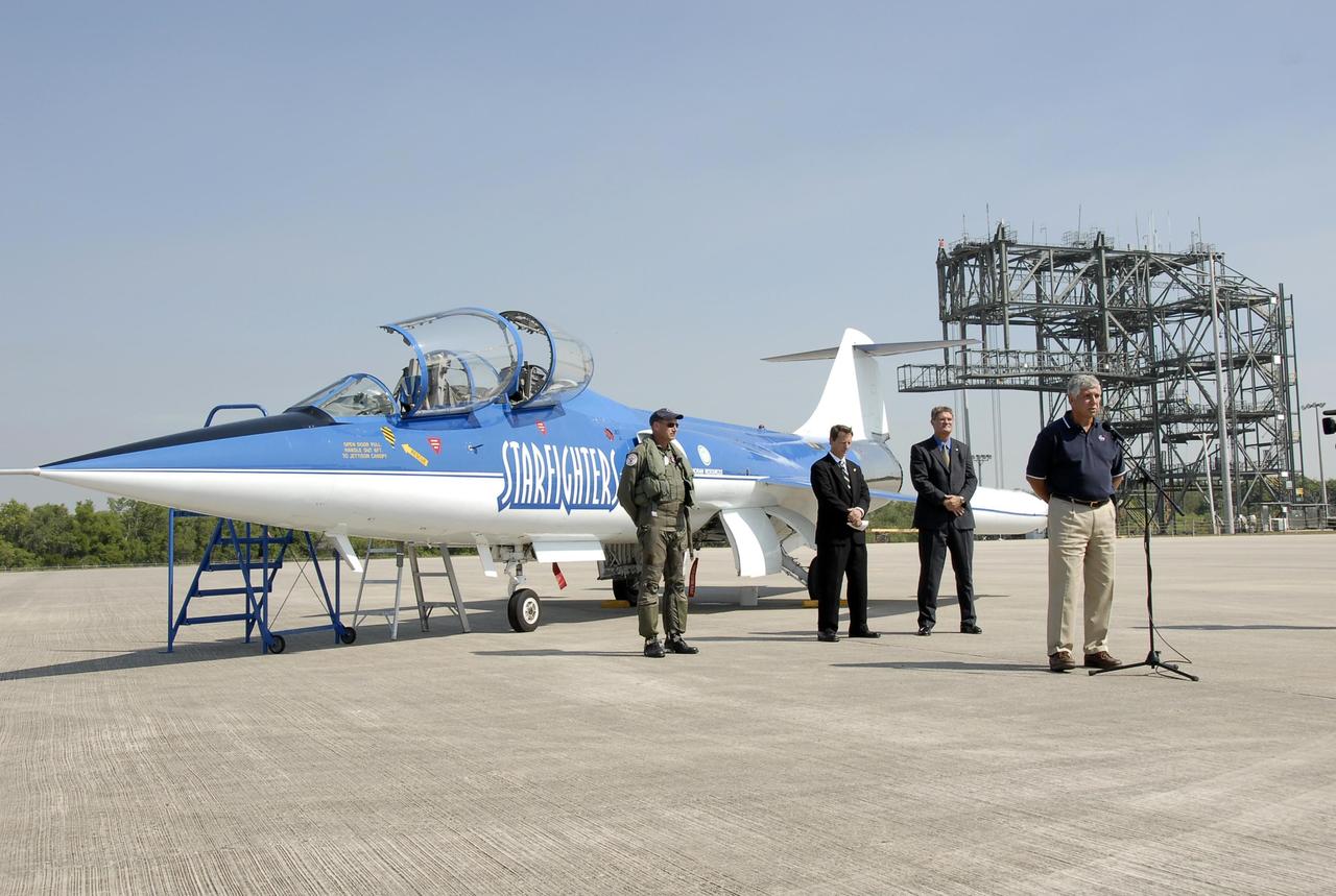 KENNEDY SPACE CENTER, FLA.  --  After a test flight of the Starfighter F-104, Jim Ball, KSC Spaceport Development manager, addresses the media.  Behind him are Pilot Rick Svetkoff; Al Wassel, a representative from the FAA Office of Commercial Space; and Bill Parsons, director of Kennedy Space Center.  The aircraft is taking part in a series of pathfinder test missions from the space shuttle runway. Two flights will generate test data to validate sonic boom assumptions about the potential impacts of suborbital and orbital commercial spaceflight from the facility. NASA is assessing the environmental impact of such flights.  Starfighters Inc. of Clearwater, Fla., will perform the flights to help in assessing suborbital space launch trajectories from the runway and paving the way for future commercial space tourism and research flights from the facility.  Photo credit: NASA/Kim Shiflett