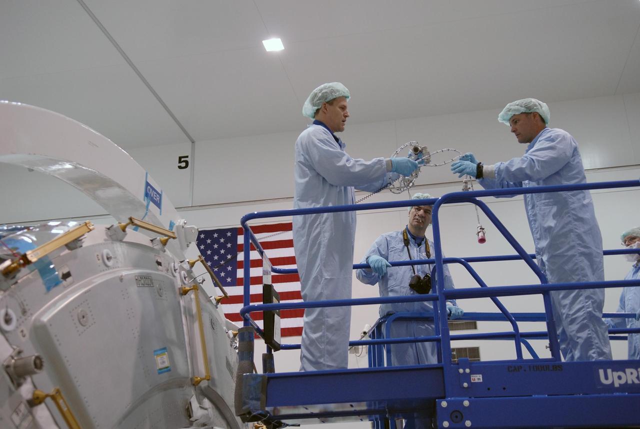 KENNEDY SPACE CENTER, FLA.  --  In the Space Station Processing Facility, STS-120 Mission Specialists Scott Parazynski (left), Paolo Angelo Nespoli (center) and Douglas H. Wheelock practice using some of the equipment for the Node 2, another element to be added to the International Space Station.  They and other crew members are at KSC for equipment familiarization.  Node 2 will provide a passageway between three station science experiment facilities: the U.S. Destiny Laboratory, the Kibo Japanese Experiment Module, and the European Columbus Laboratory.  STS-120 is targeted for launch on October 20.   Photo credit: NASA/Kim Shiflett